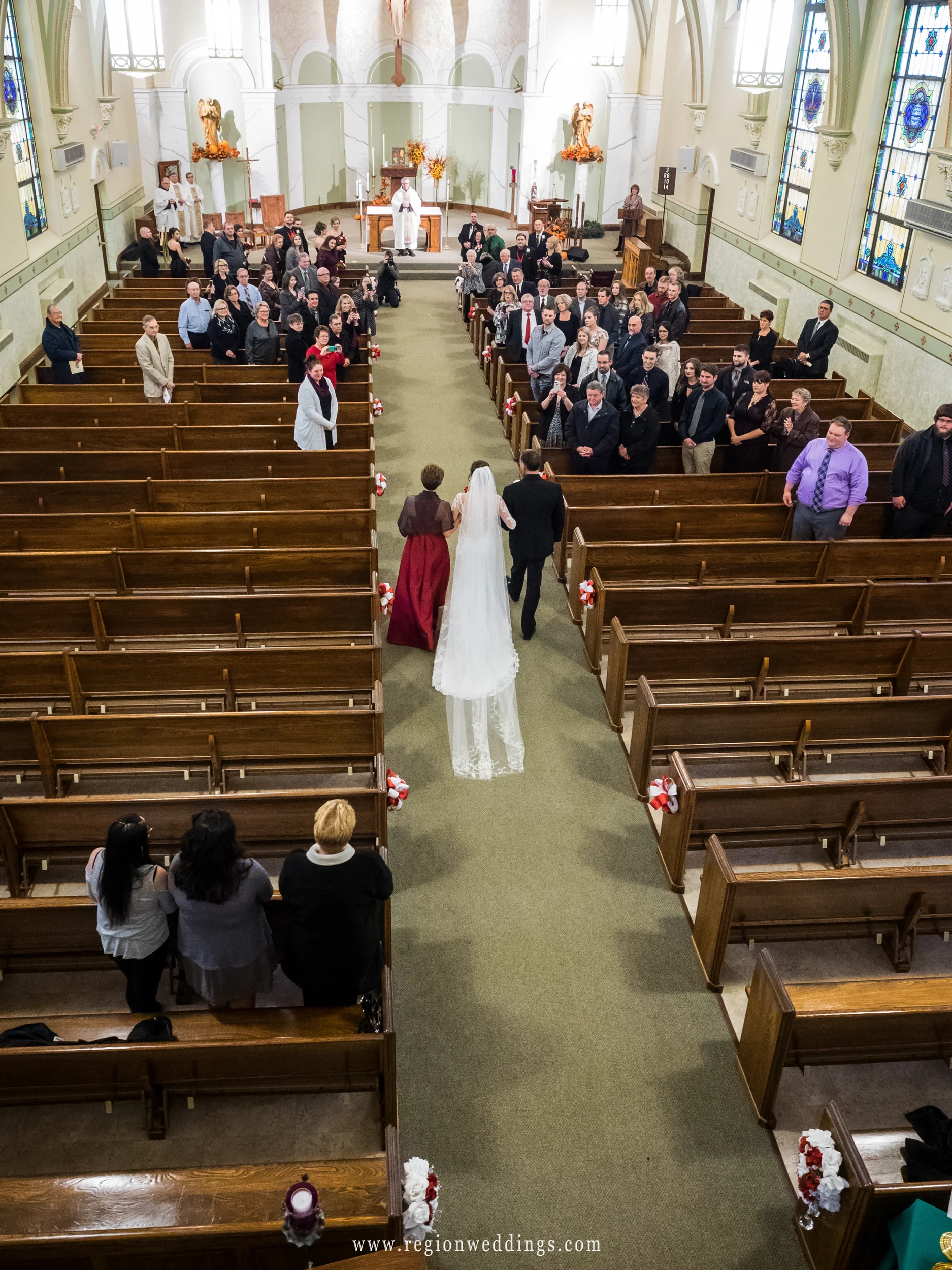 The bride walks down the aisle at Holy Name Catholic Church.