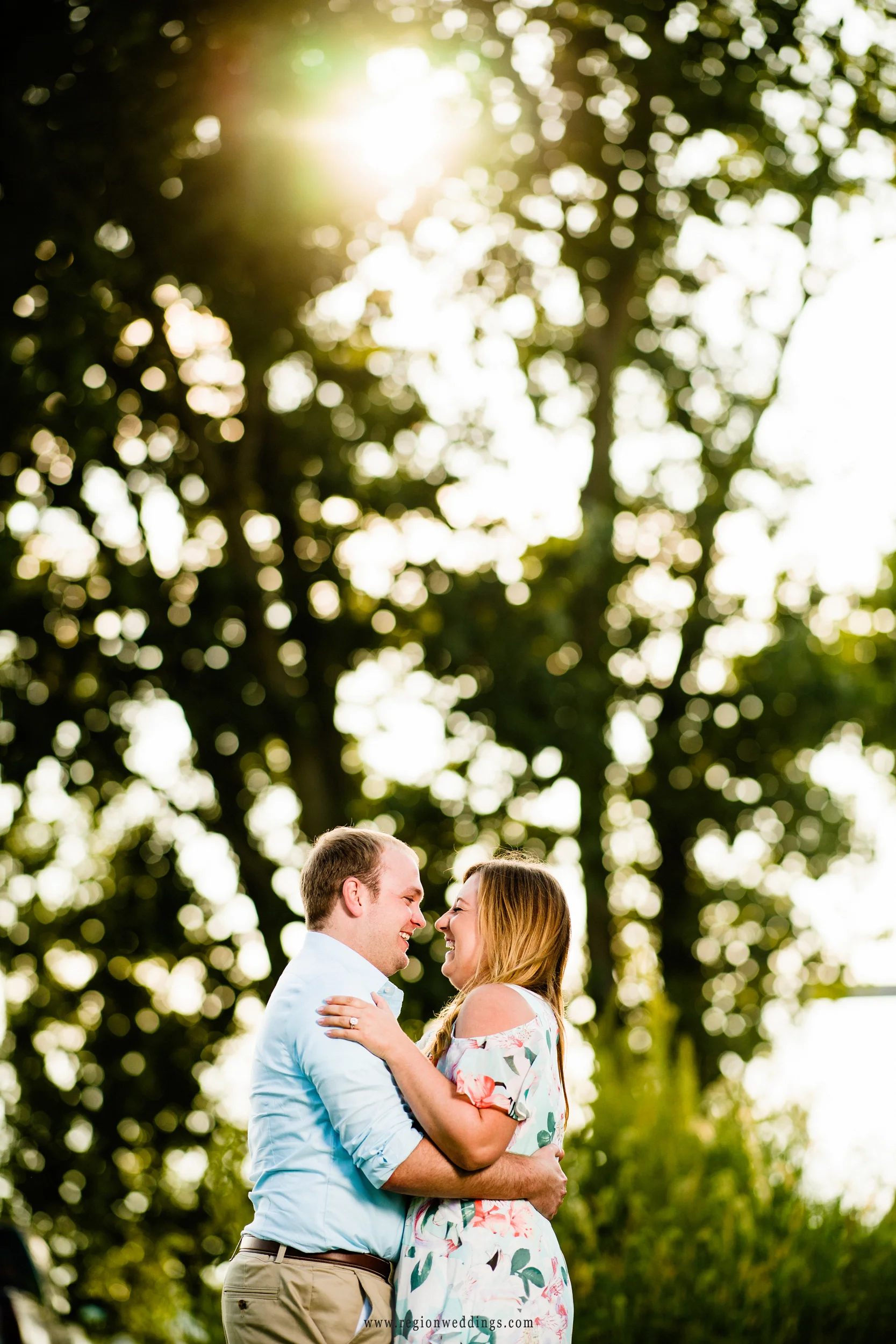 Sun peeks through the trees onto a young couple in love.