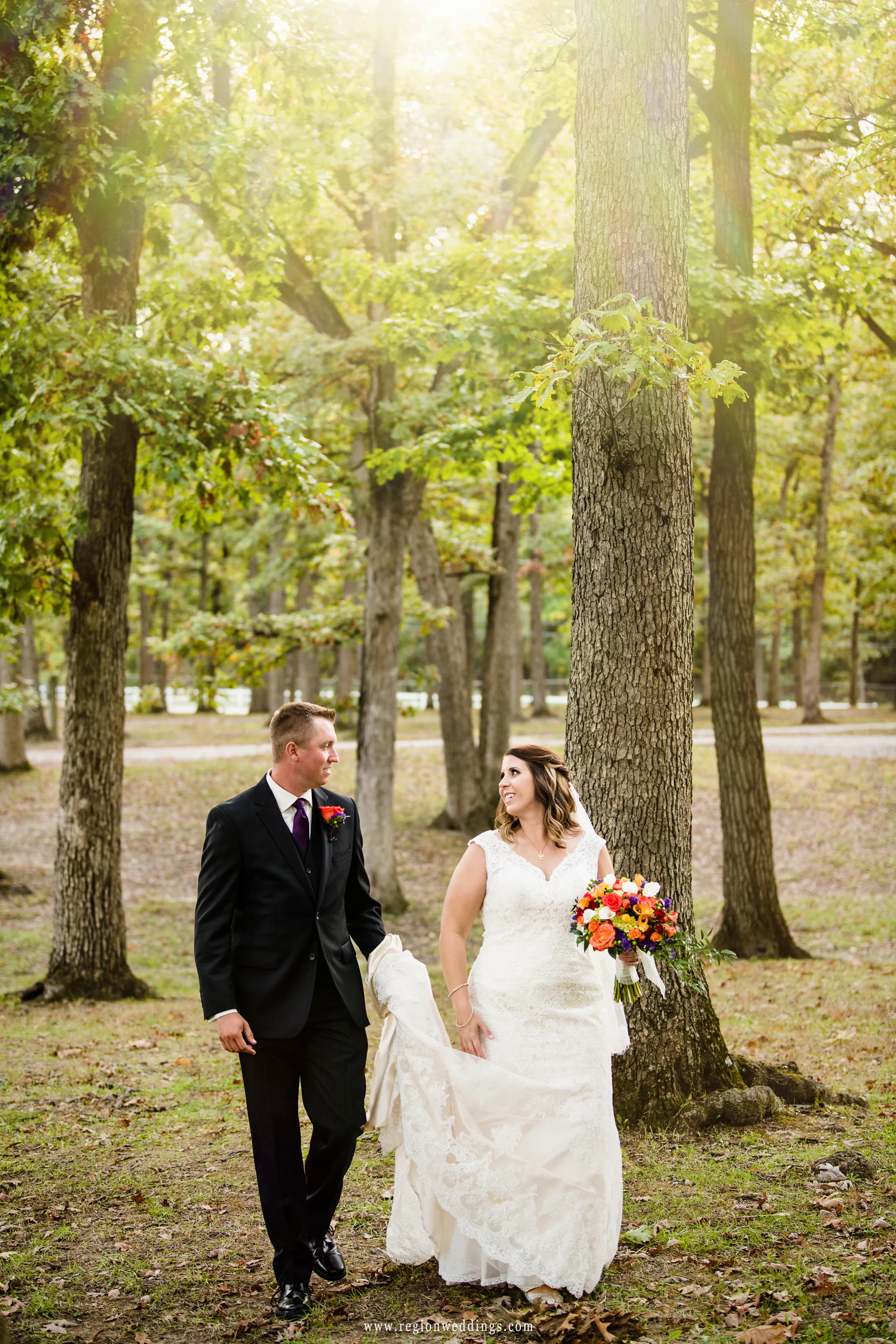 The bride and groom take a stroll in the wood at Lake County Fairgrounds.