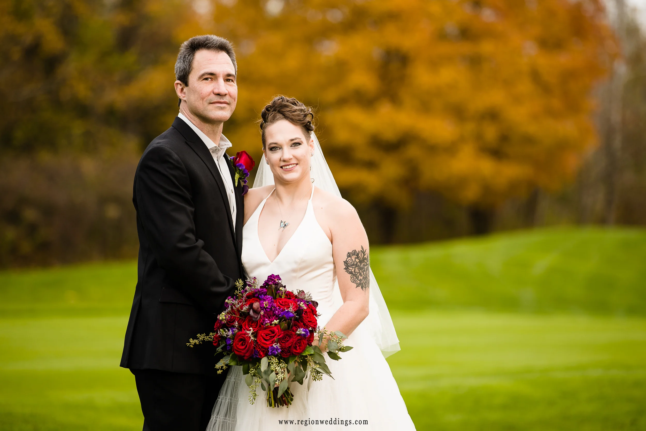 Fall color surrounds the Sand Creek golf course for bride and groom portraits.