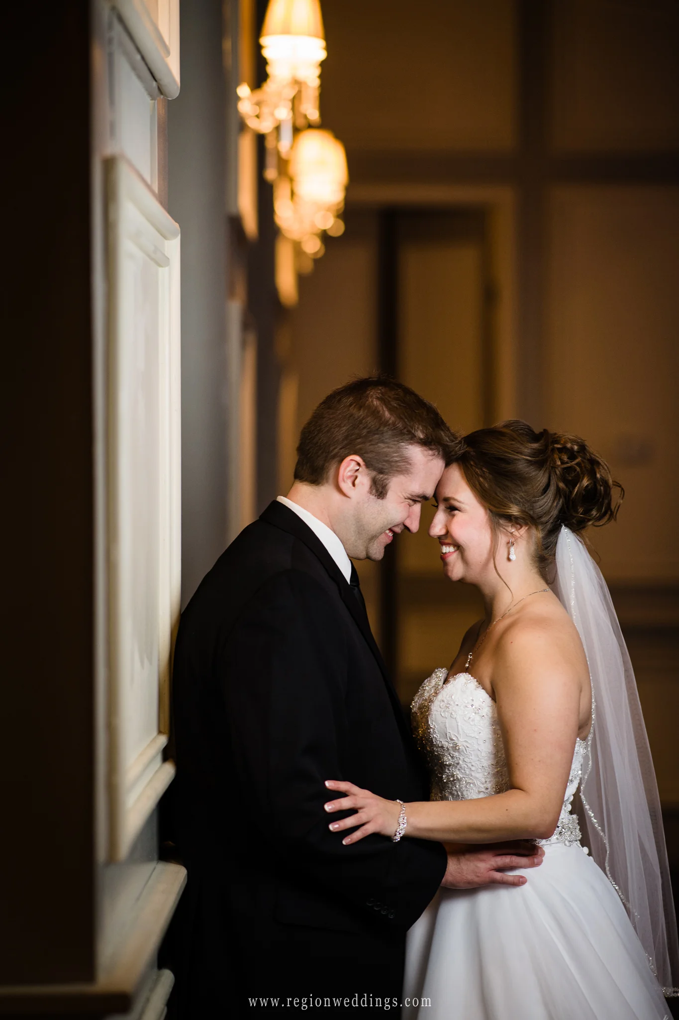 Bride and groom embrace inside the ballroom of Uptown Center for Performing Arts.