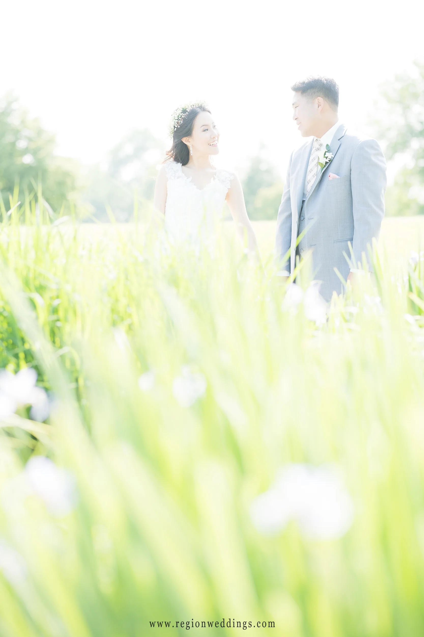 Bride and groom soak up the sun in this backlit wedding picture.