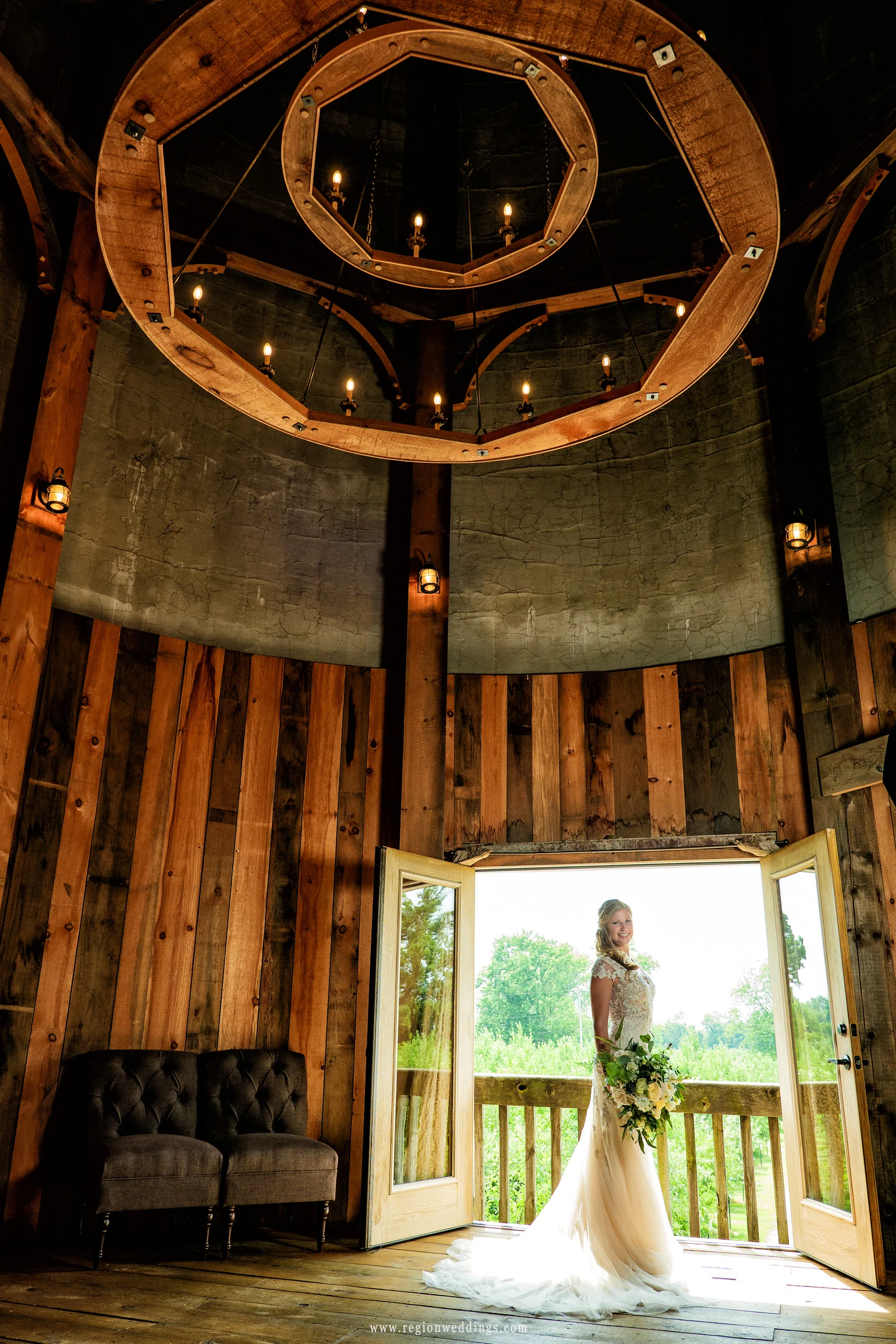 A lighted chandelier towers over the bride inside the grain silo at County Line Orchard.