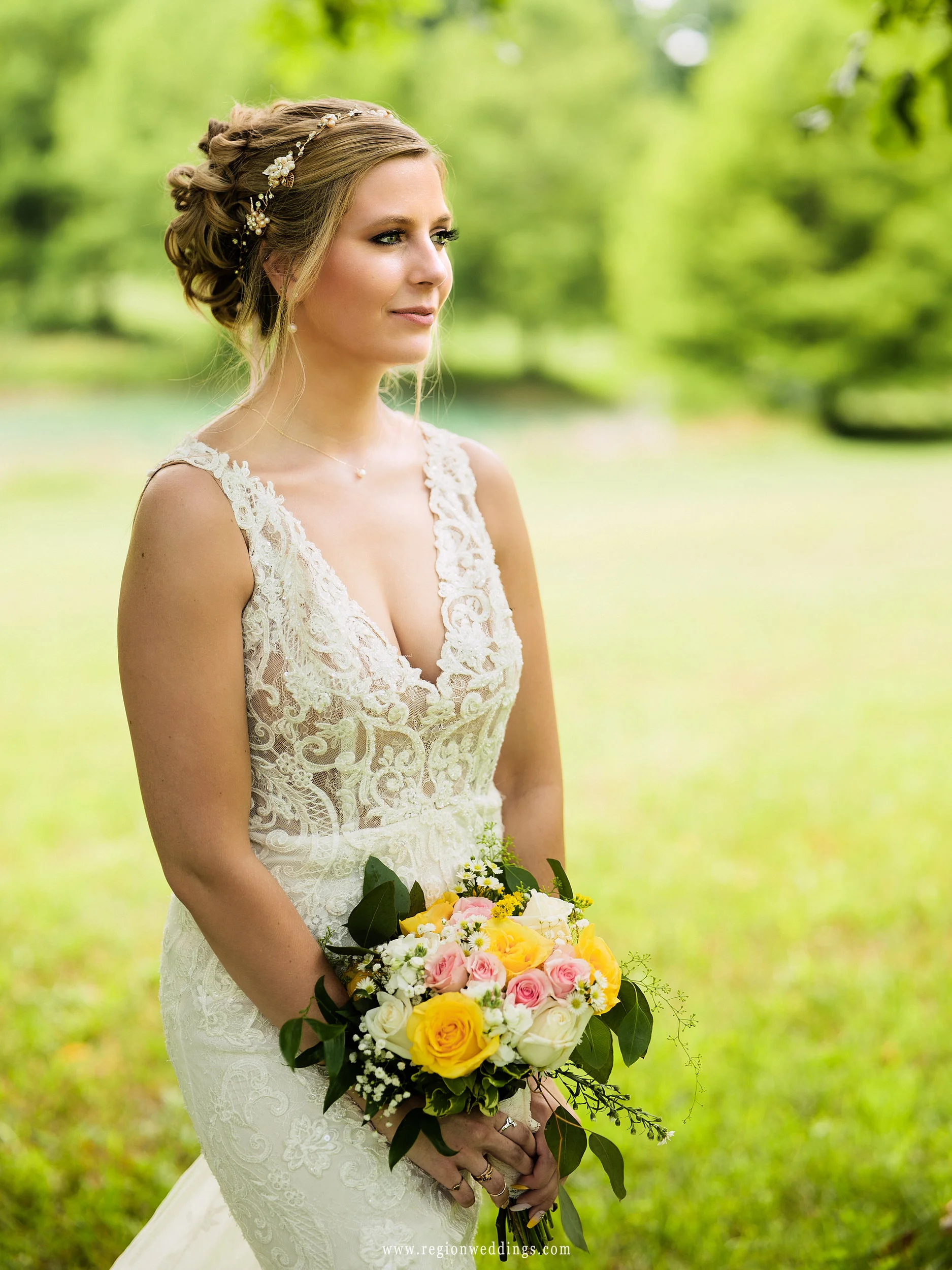 The bride looks across the beautiful green fields on her wedding day.