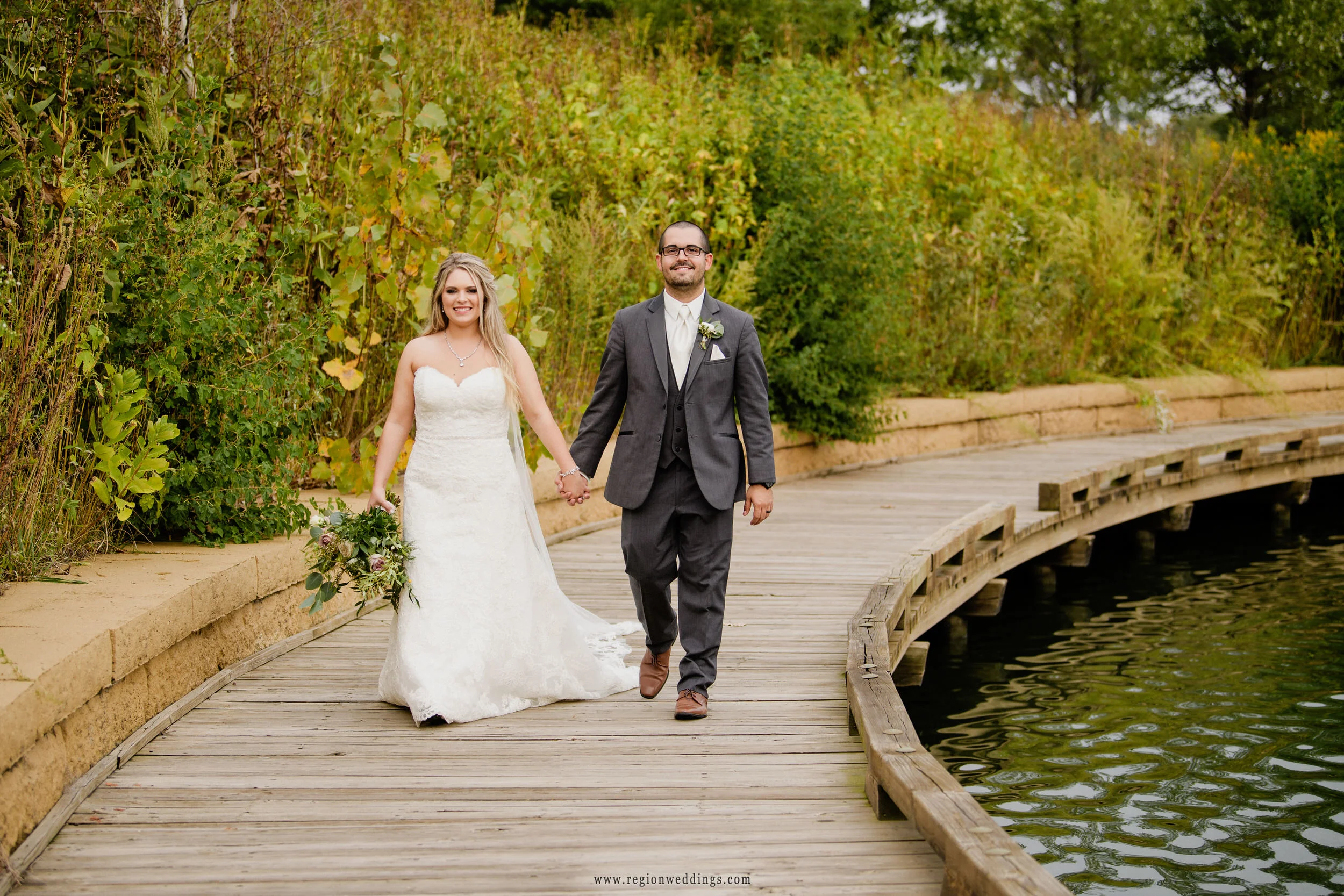 Bride and groom take a walk along the lake at Centennial Park in Munster, Indiana.