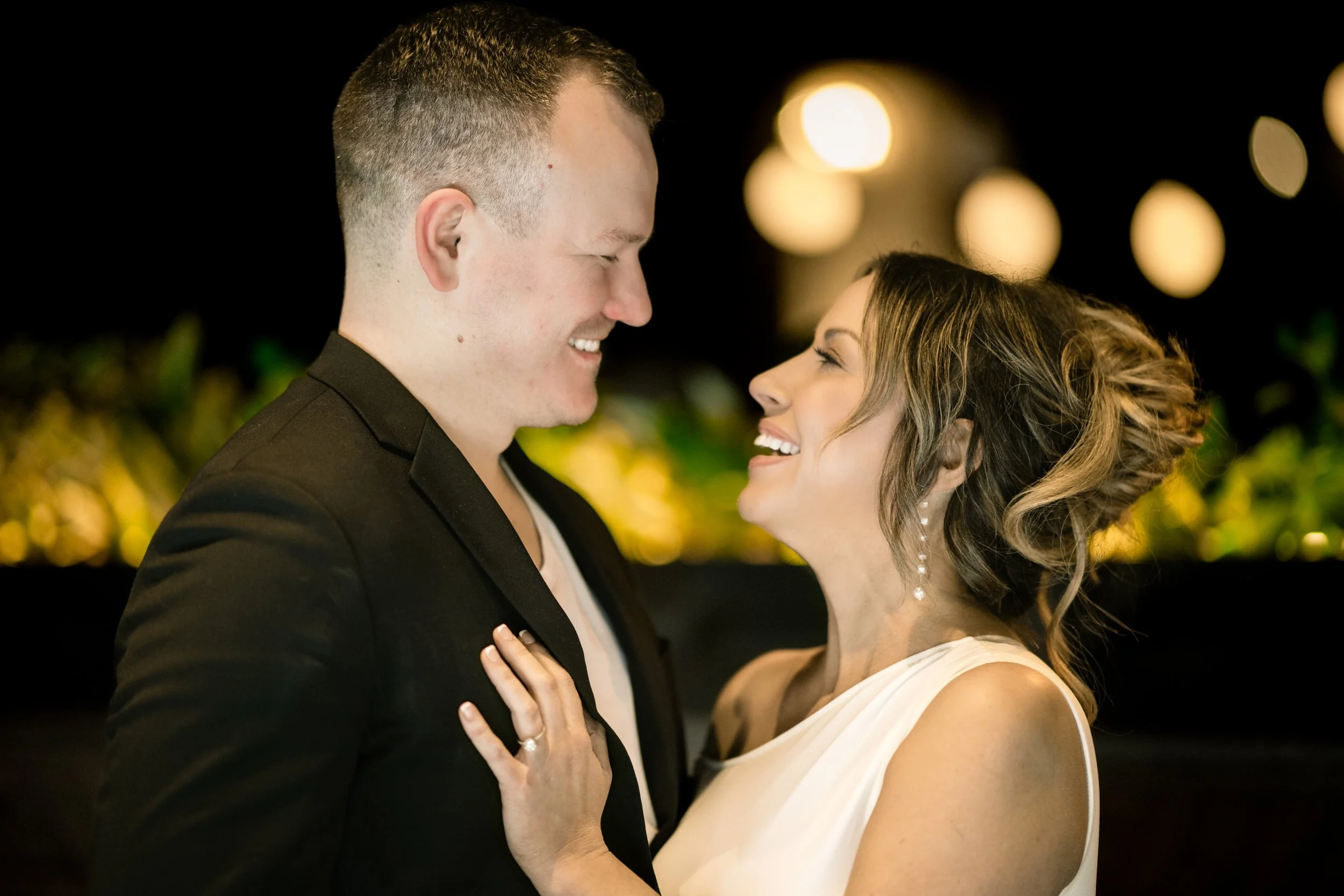An intimate moment during an engagement session with warm lighting in the background.