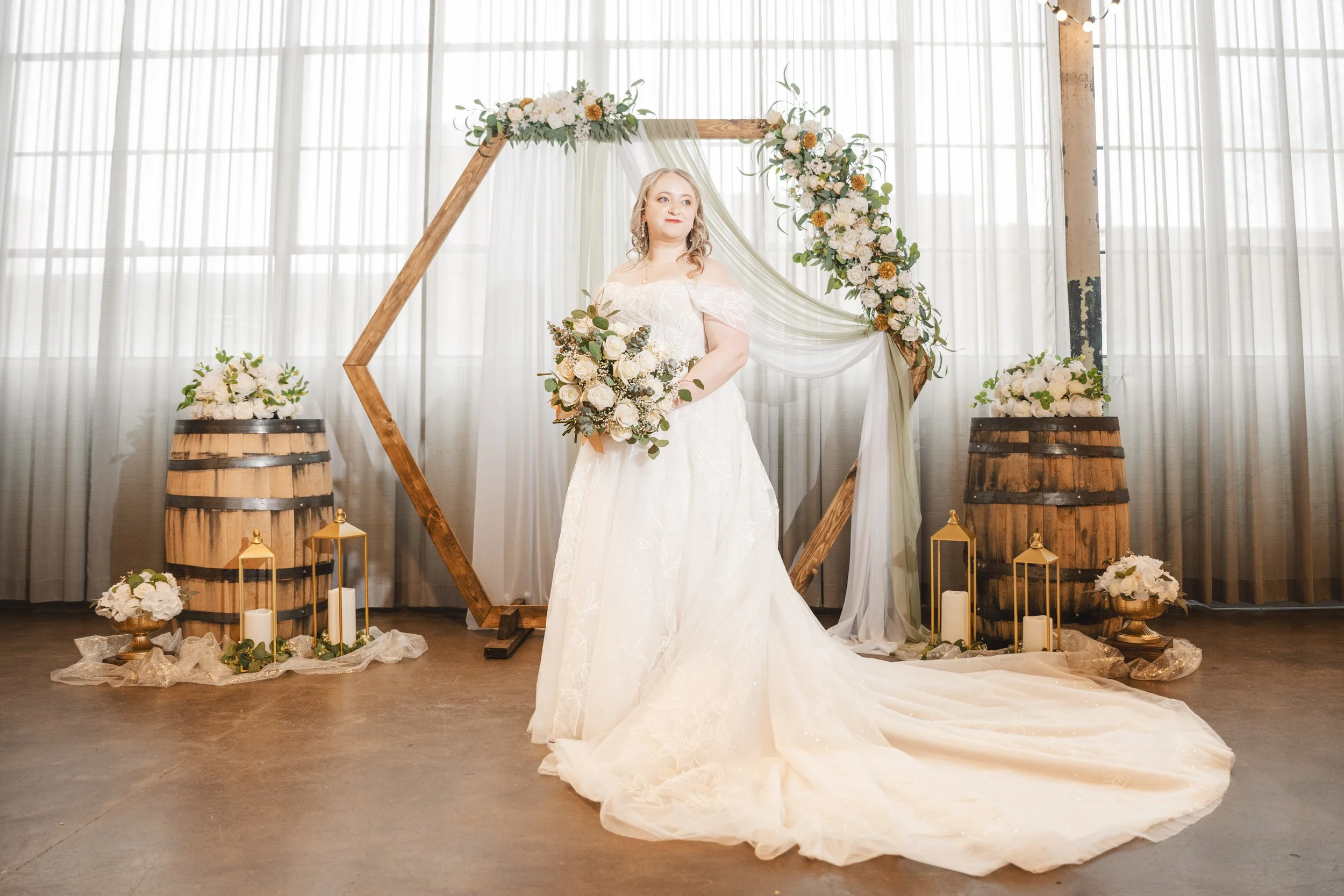 The bride stands in front of a wooden archway at Journeyman Distillery in Valparaiso, Indiana.