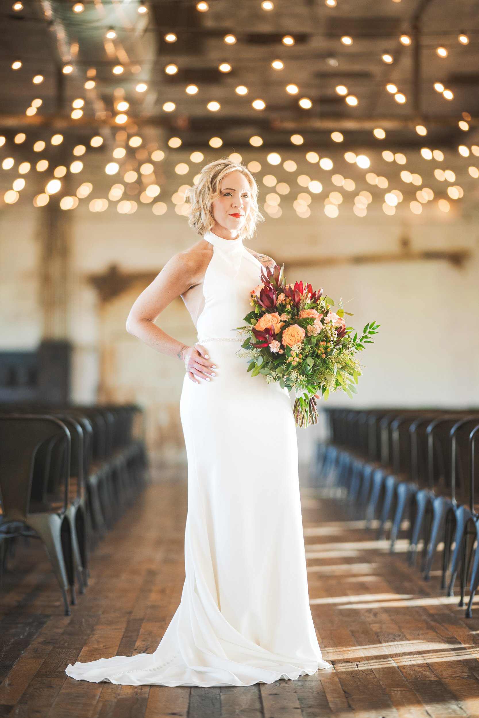 A bride stands inside the industrial looking loft at Journeyman wedding venue in Three Oaks, Michigan.