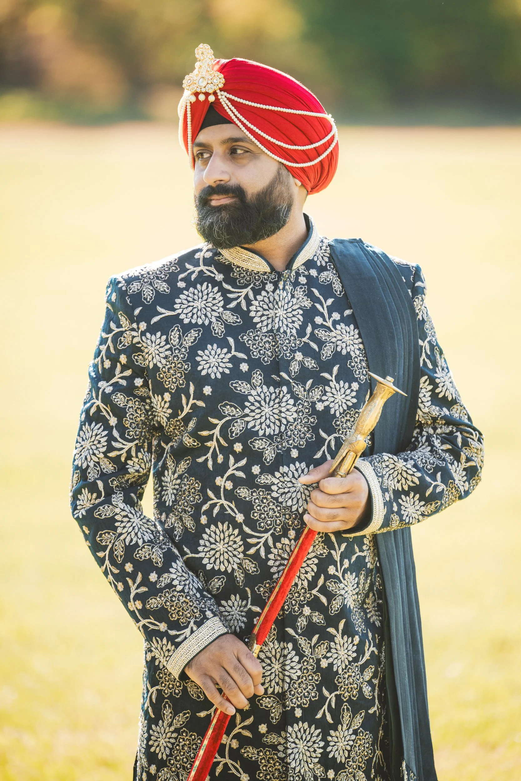 An Indian groom grasps his sword before his grand entrance.