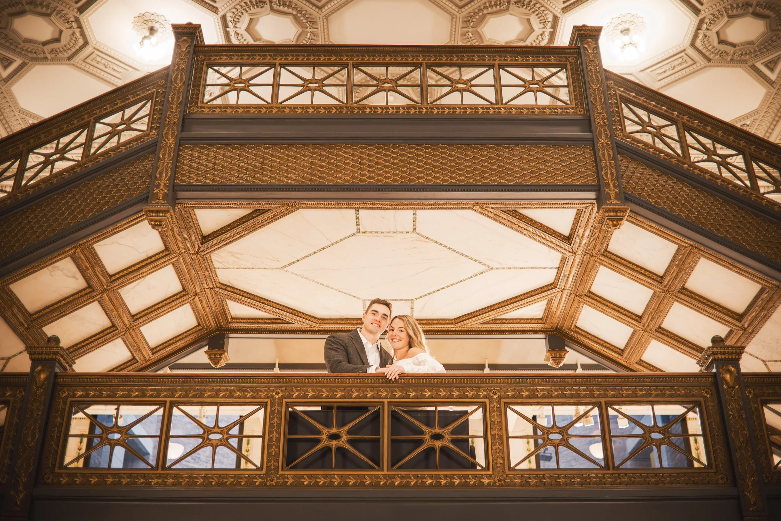 European architecture towers above a couple during their photo session at the Chicago Cultural Center.