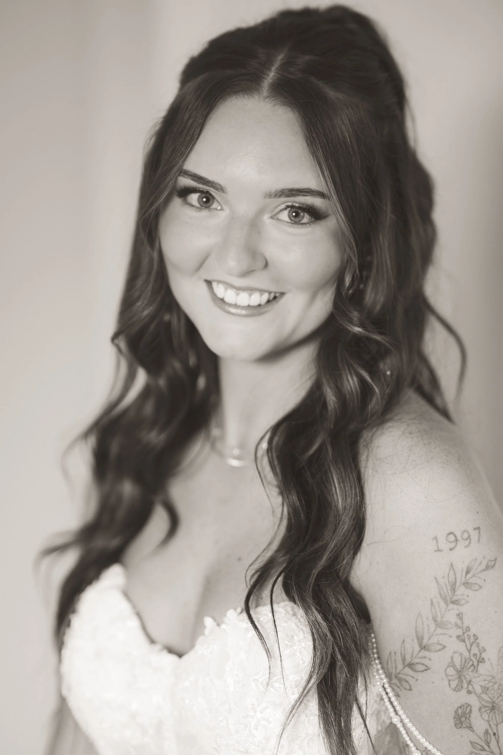 Black and white close up of the bride's smiling face on her wedding day.