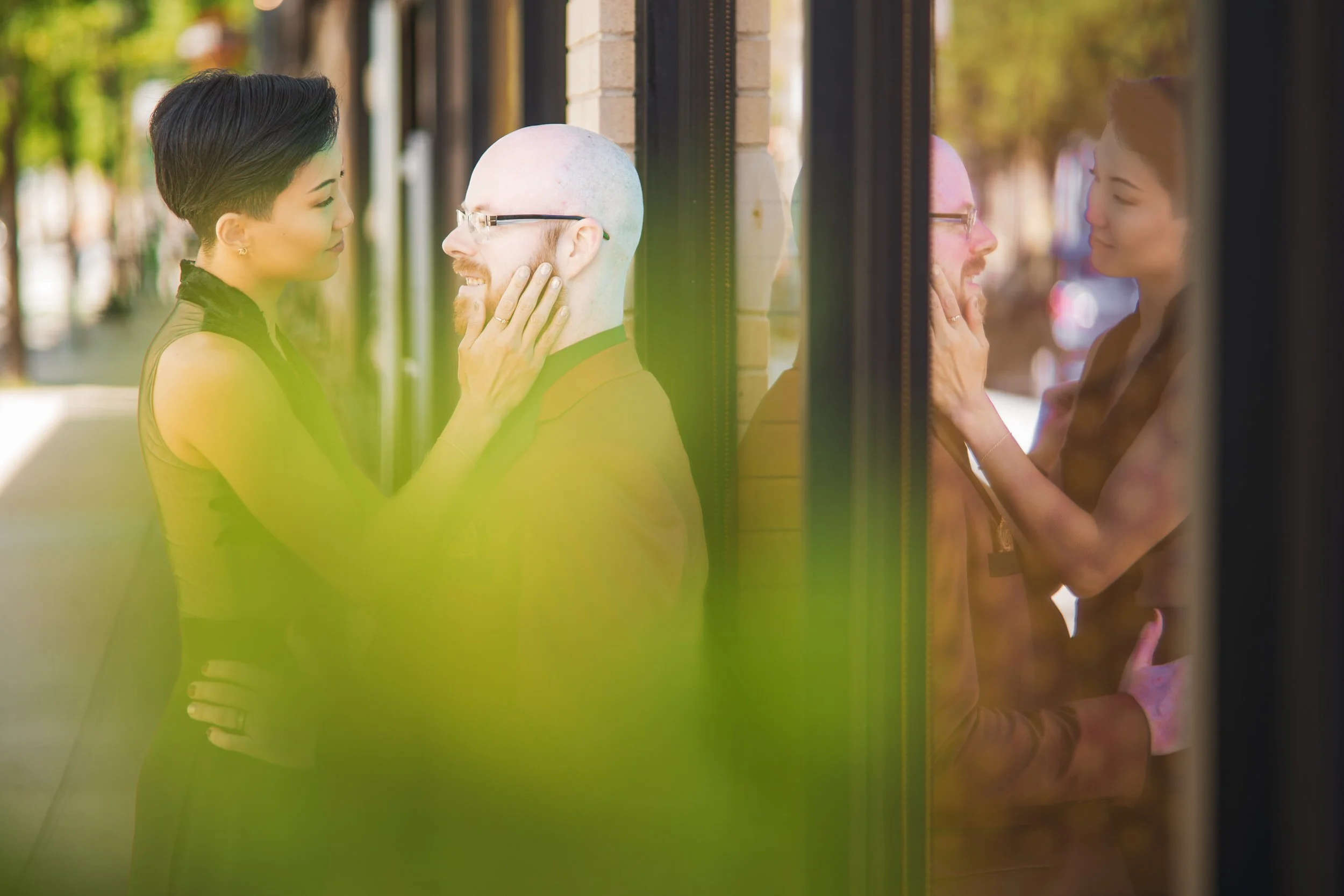 A romantic moment as a bride in a black dress caresses the cheek of the groom.