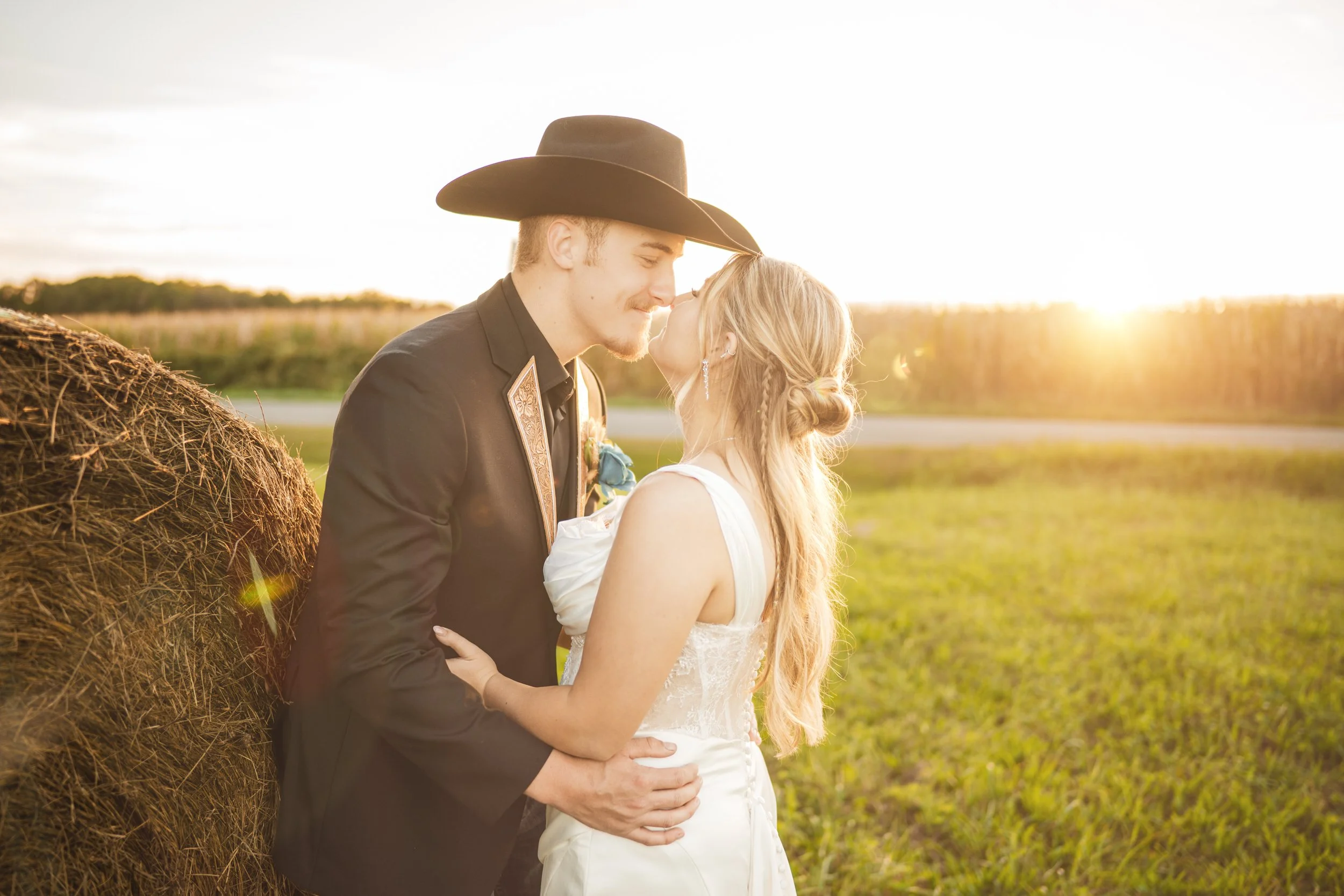 A bride and groom nuzzle noses during golden hour on an Indiana farm.