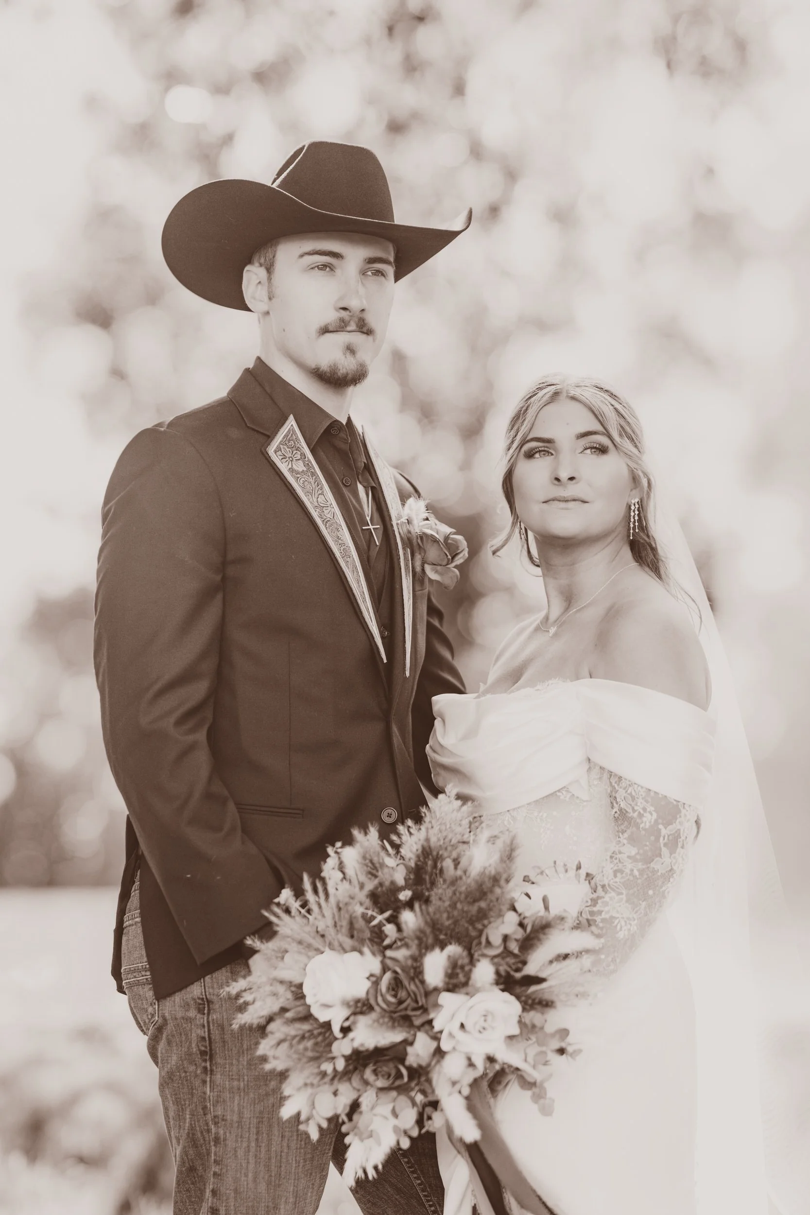 A black and white image of a bride and groom in western wear.