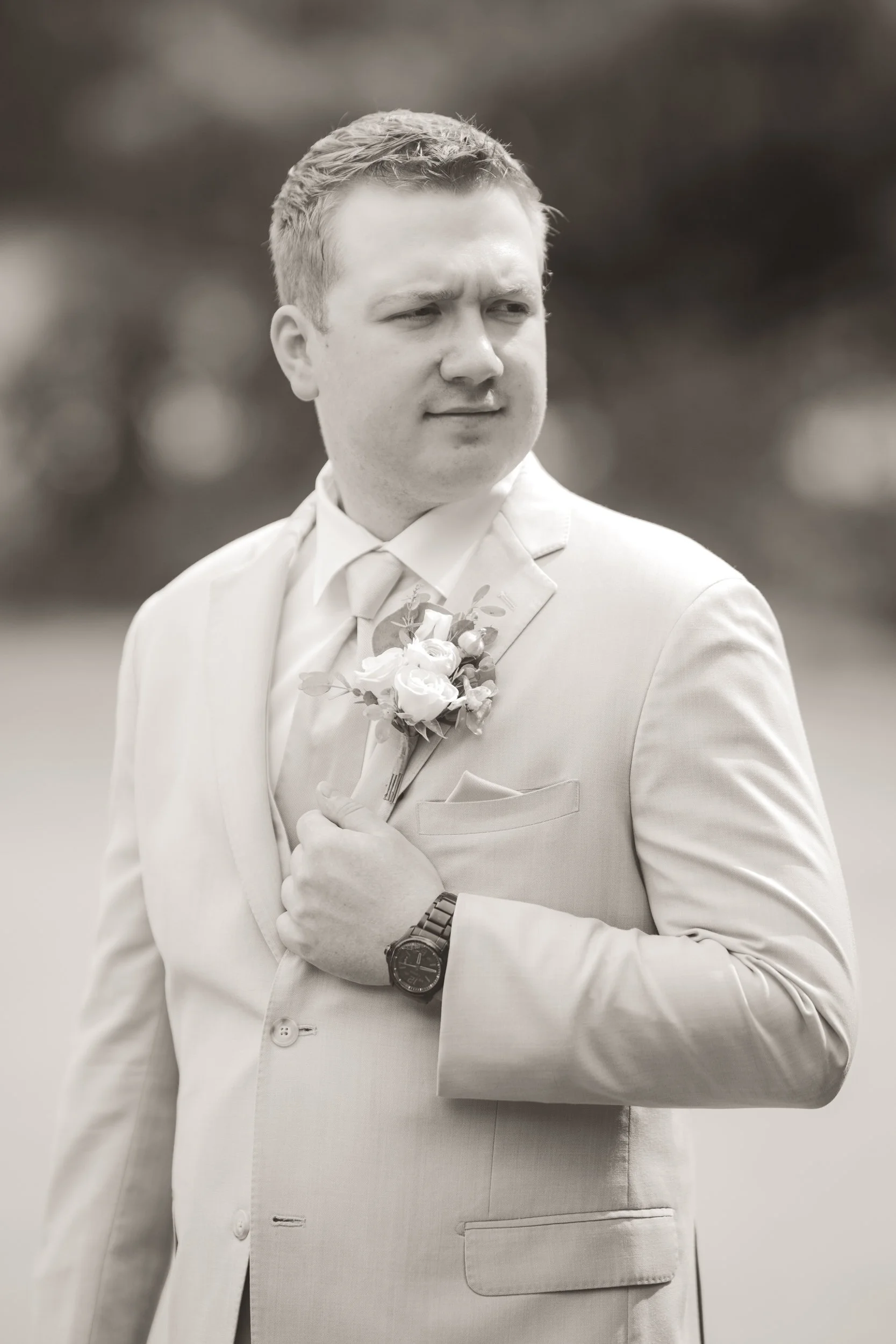 A black and white image of the groom looking off in the distance.