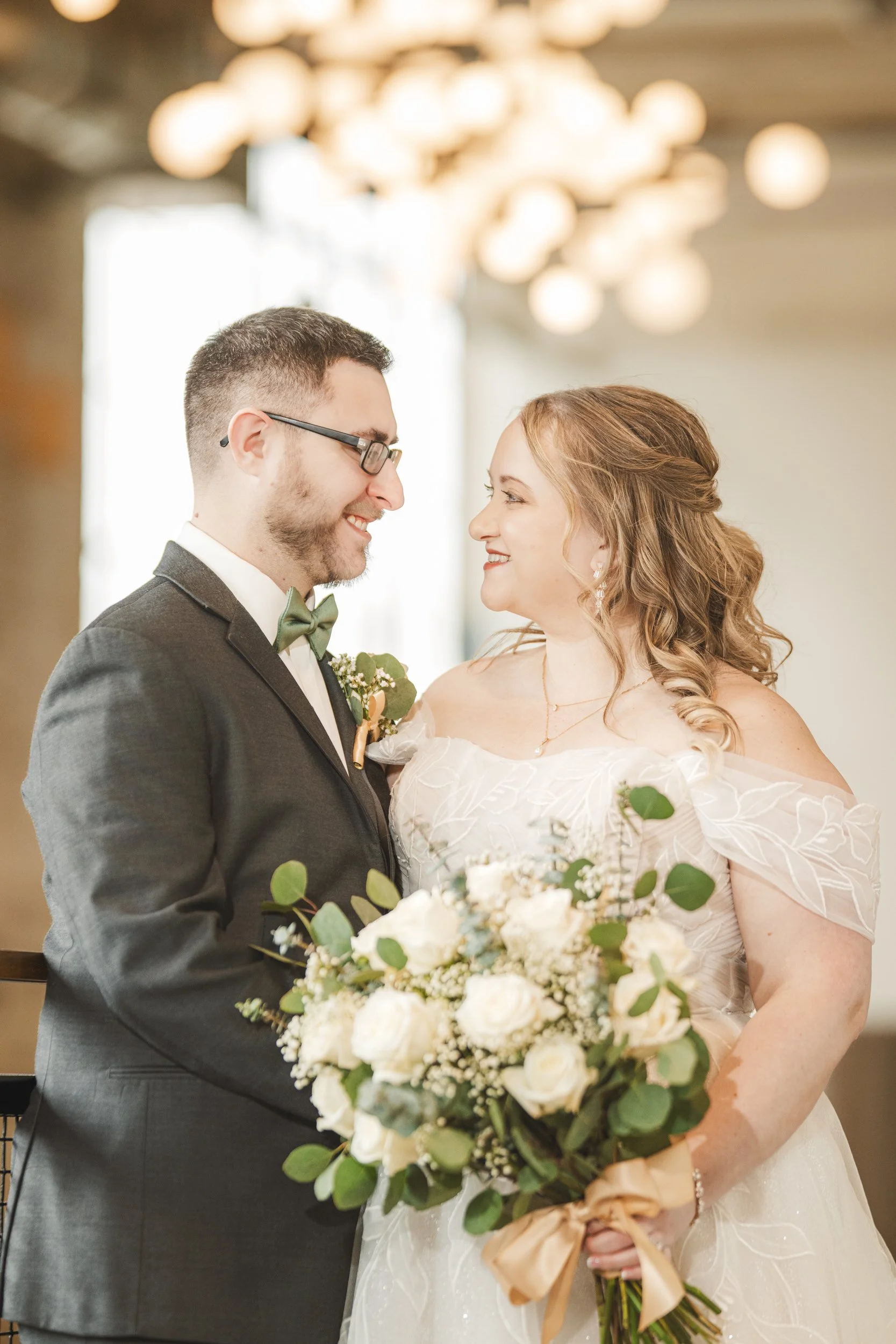 The groom and his bride share a moment looking at each other with intent.