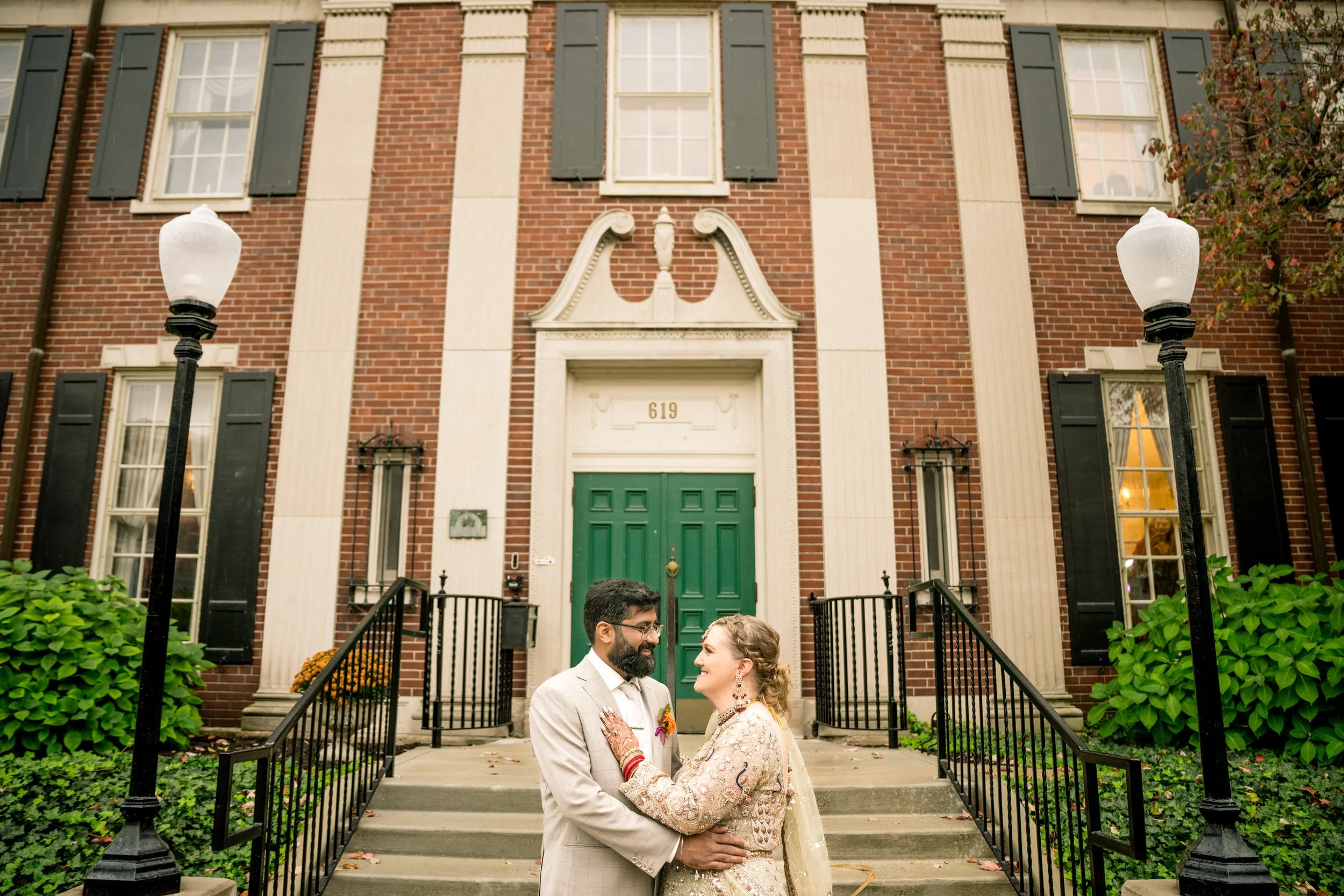 The bride and groom embrace at the entrance to Duncan Hall in Lafayette, Indiana.