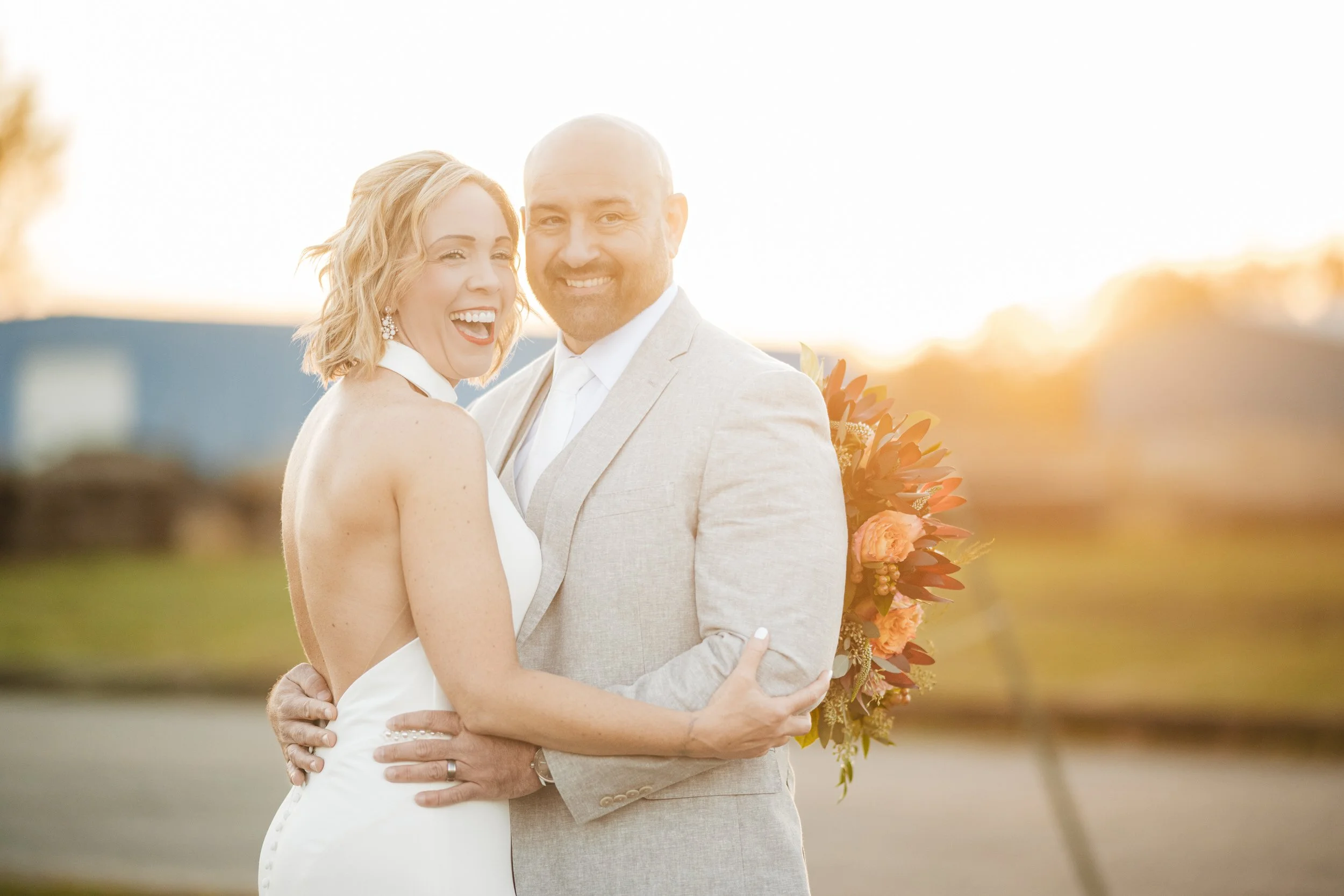 A candid moment between a bride and groom during sunset.
