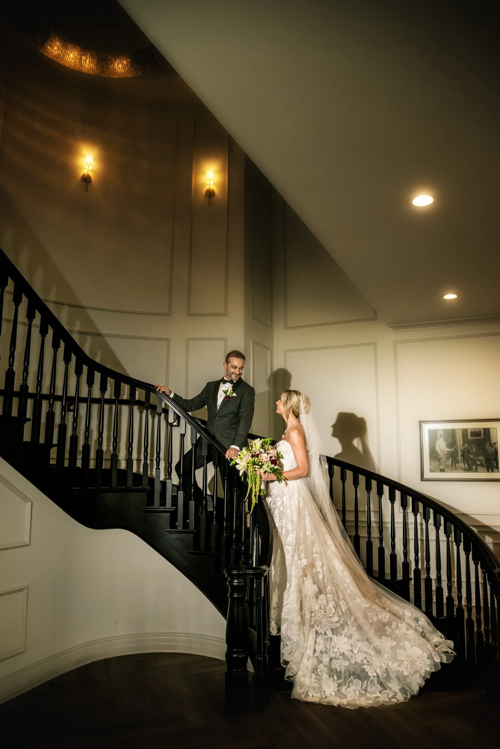 Bride and groom ascend the black and white staircase at Illinois wedding venue Midlothian Country Club.