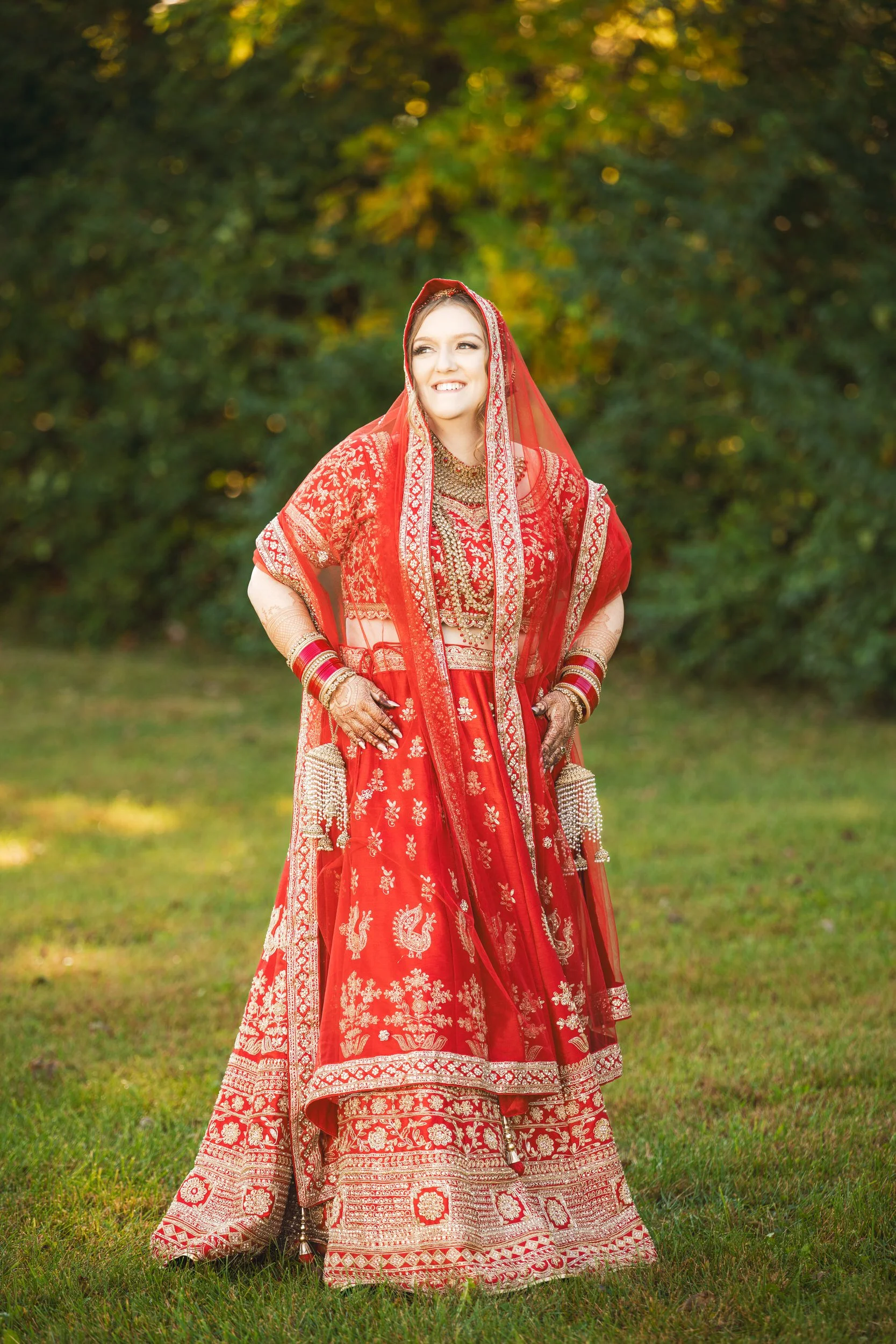 A bride in a vibrant red Indian wedding dress.