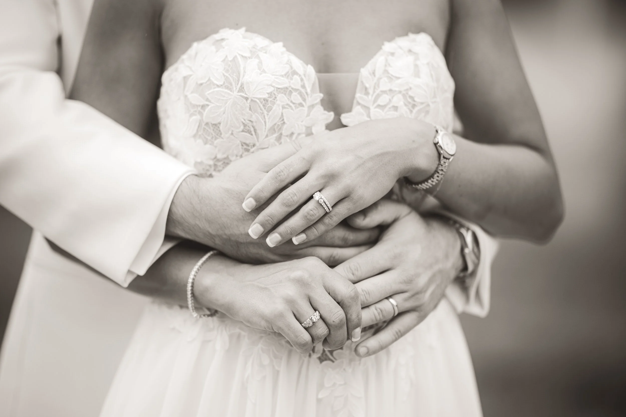A close up image of the bride and groom's hands with their wedding rings on.