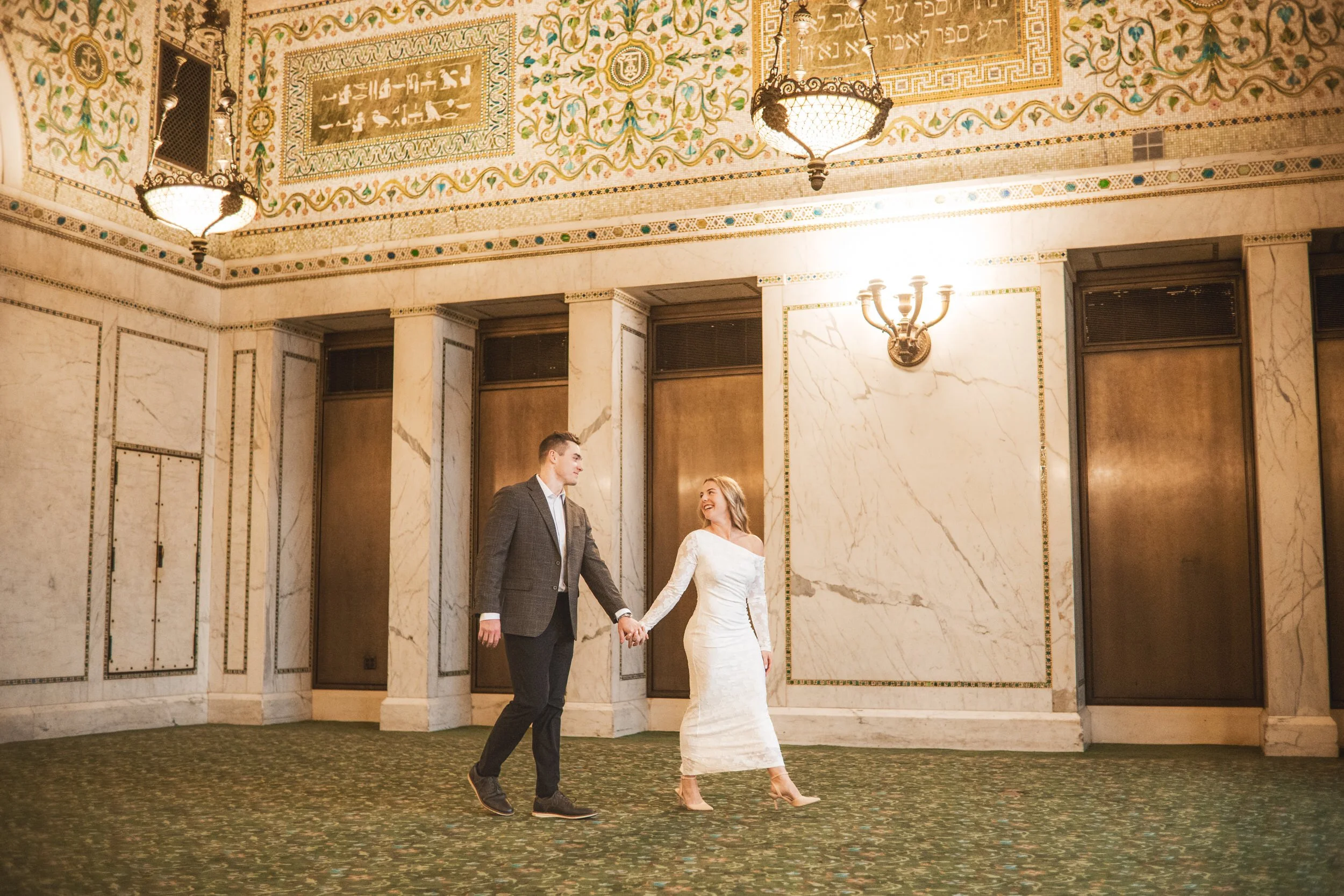 A Chicago engagement photographer captures a couple walking inside the cultural center on Michigan Avenue.