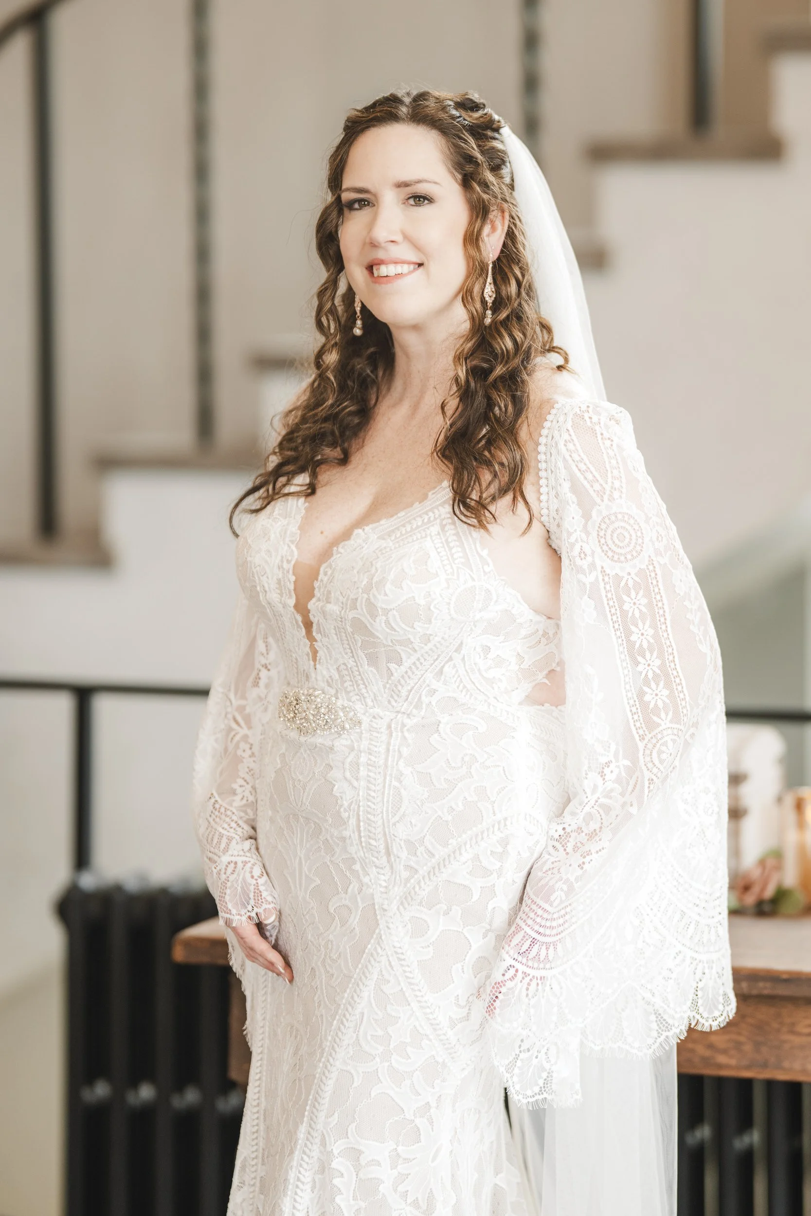 A smiling bride stands in the vestibule of Barker Hall at Trinity Church in Michigan City.