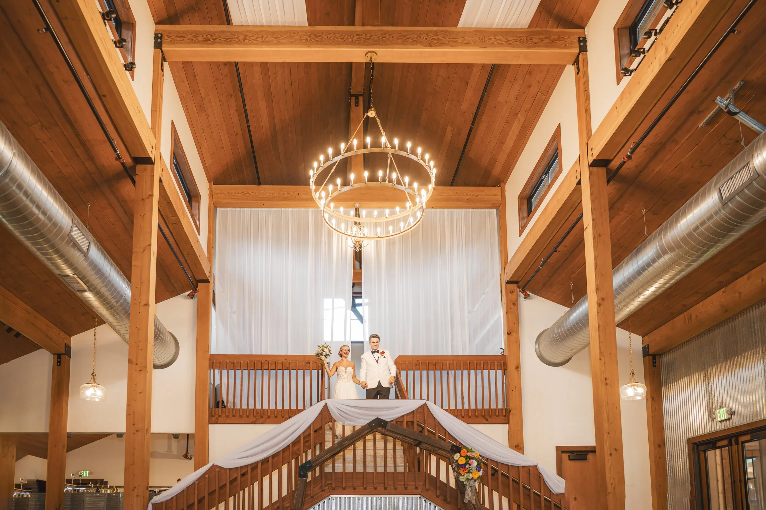 The bride and groom make a grand entrance to their wedding reception down the stairs at White Oak Farm Venue.