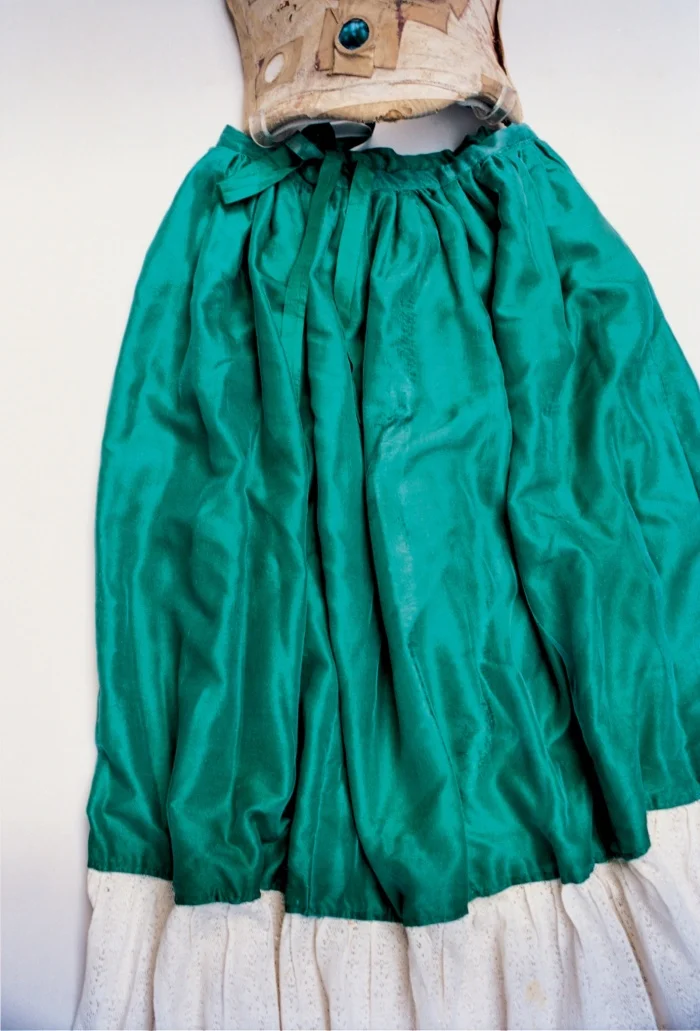 A skirt of green silk and lace attached to a body corset