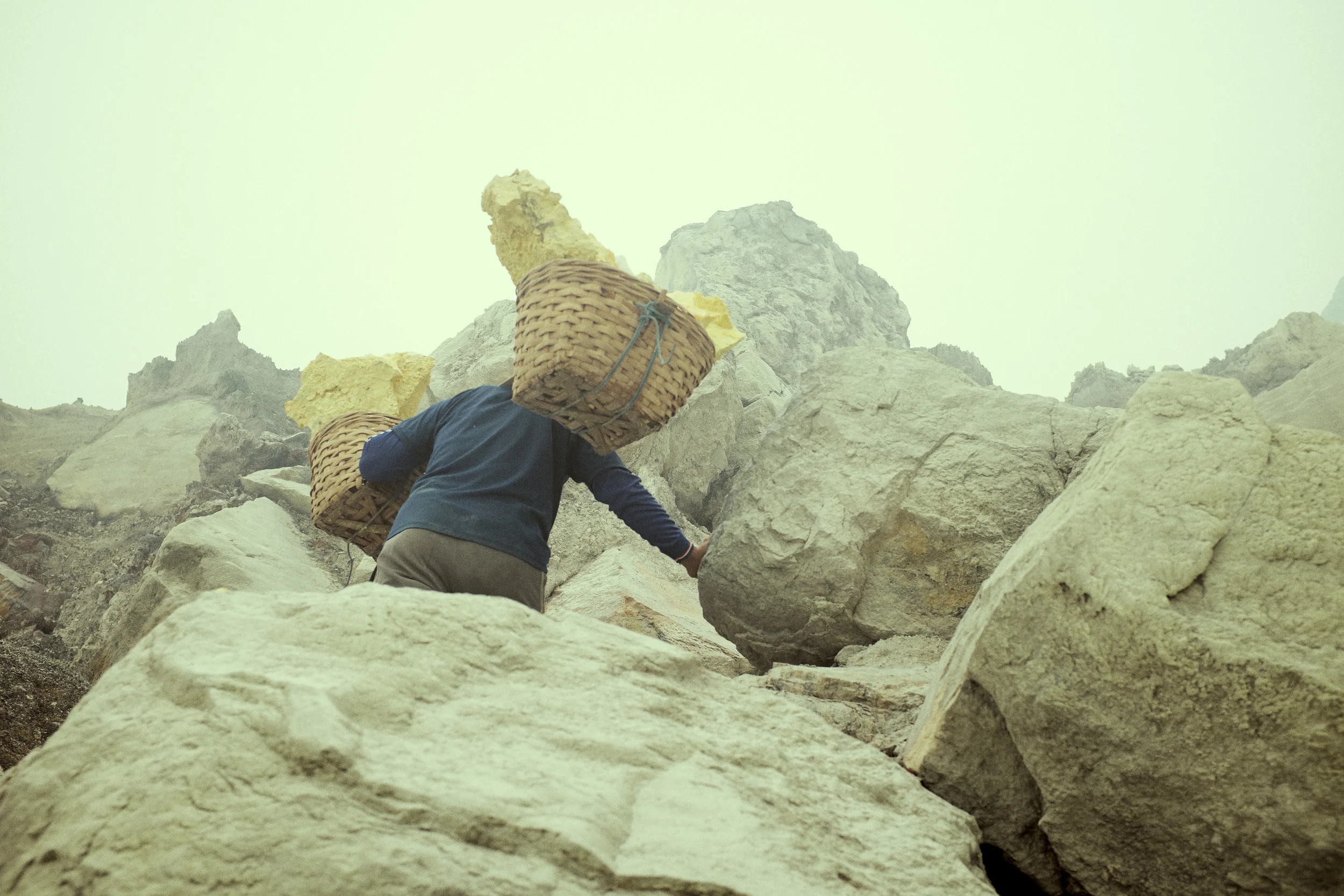 These are not straight forward paths, climbing scrambling up the crater. The miners are very sure footed. Ijen Crater, Java, Indonesia. Ijen is mined for sulphur. ©Laurence Gibson