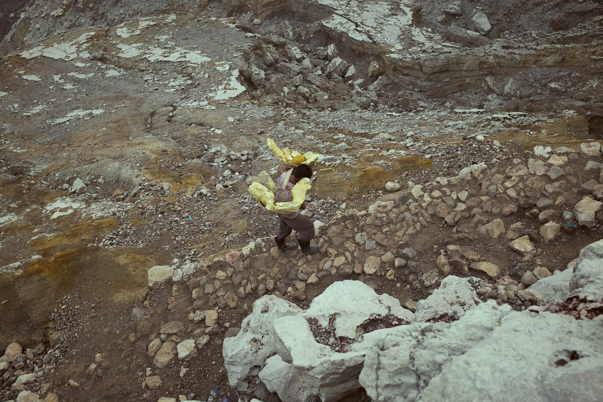 Miners carry their loads from the crater to weigh station at bottom of mountain, loads can be upwards of 100 kg. Ijen Crater, Java, Indonesia. Ijen is mined for sulphur. ©Laurence Gibson