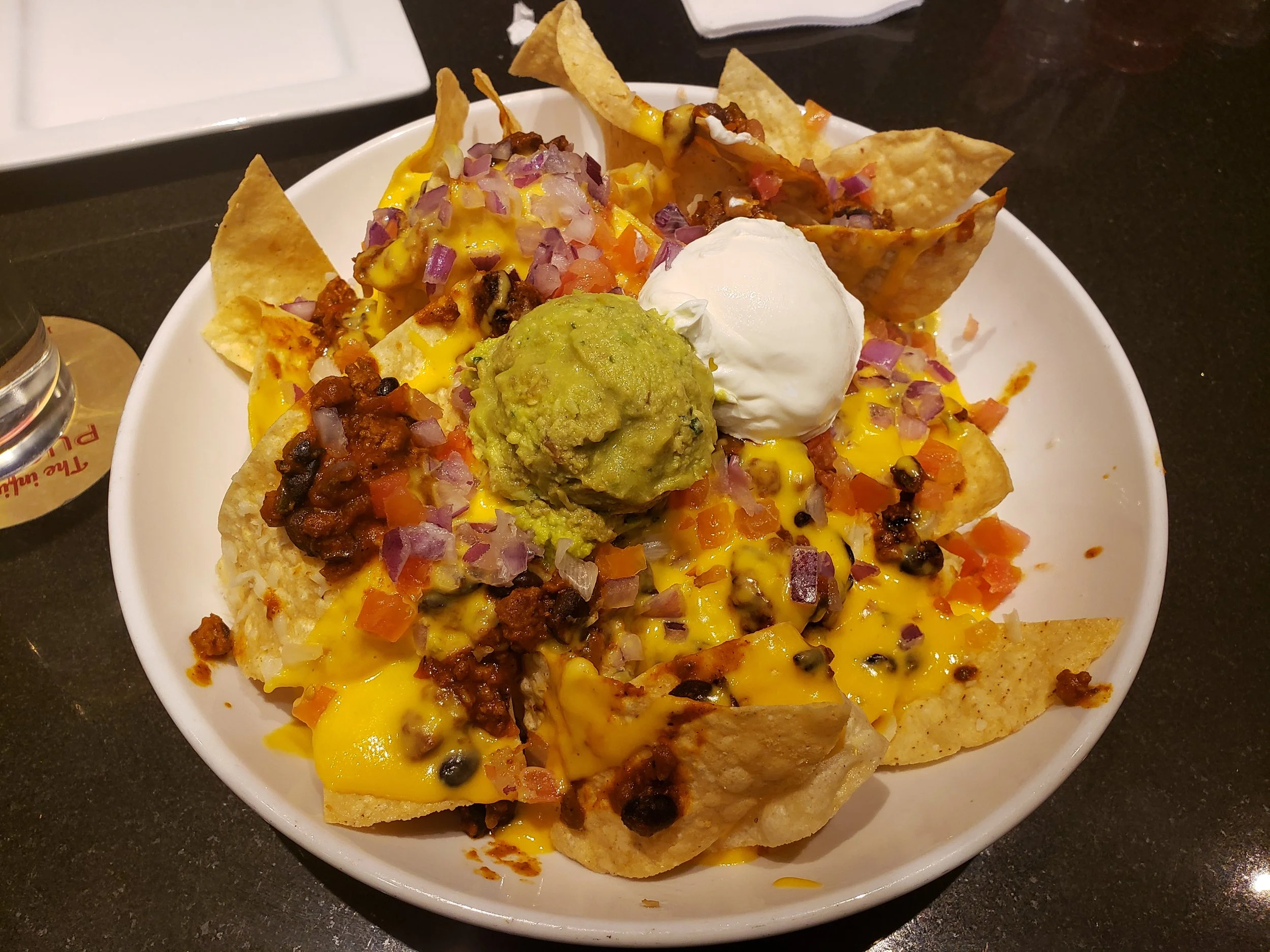 Sea Salted Tortilla Chips, Red's Chili Chili™, Two Cheeses, Guacamole, Tomatoes, Red Onion, Salsa, Sour Cream, Cilantro