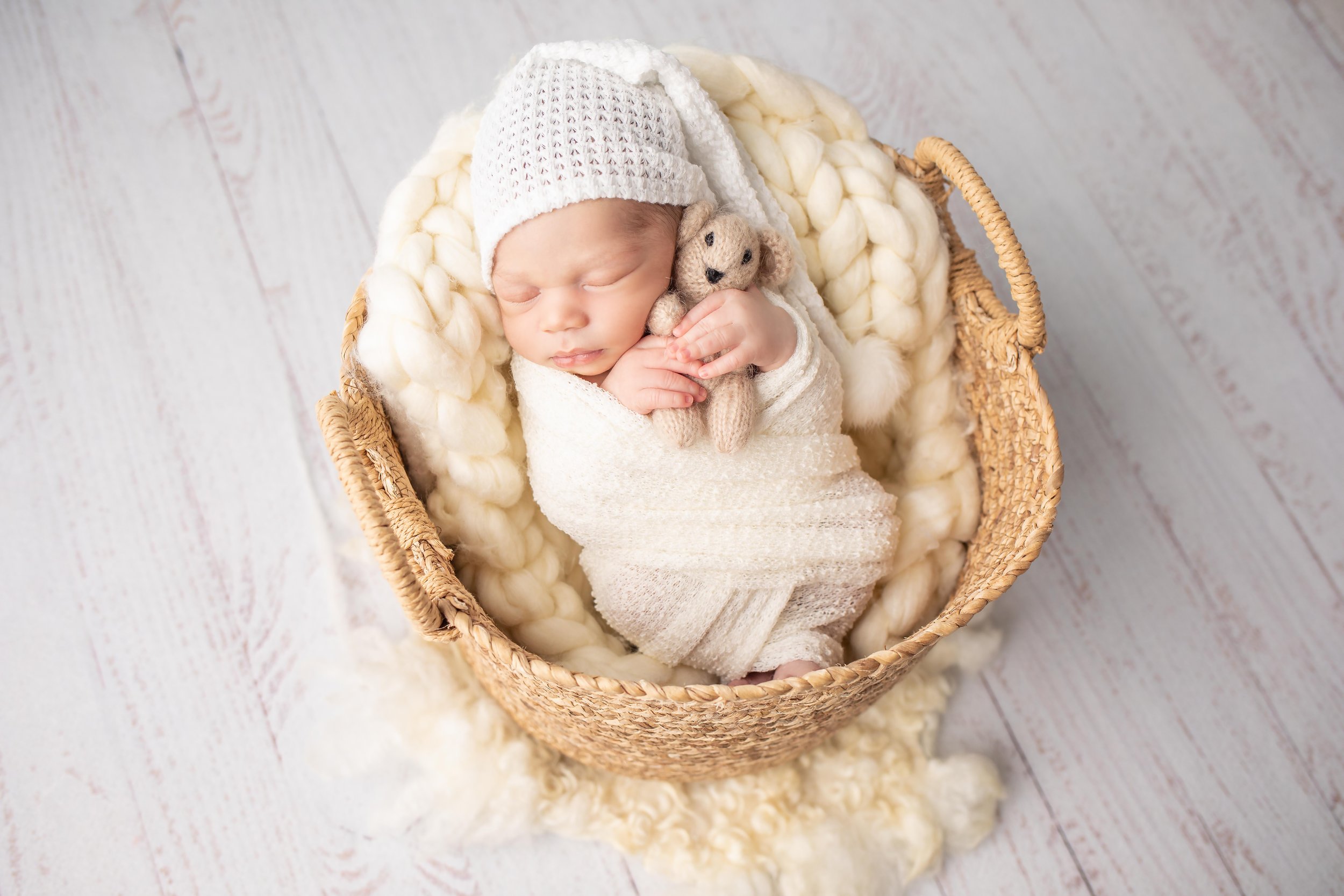 Newborn snuggles with teddy bear Charlotte
