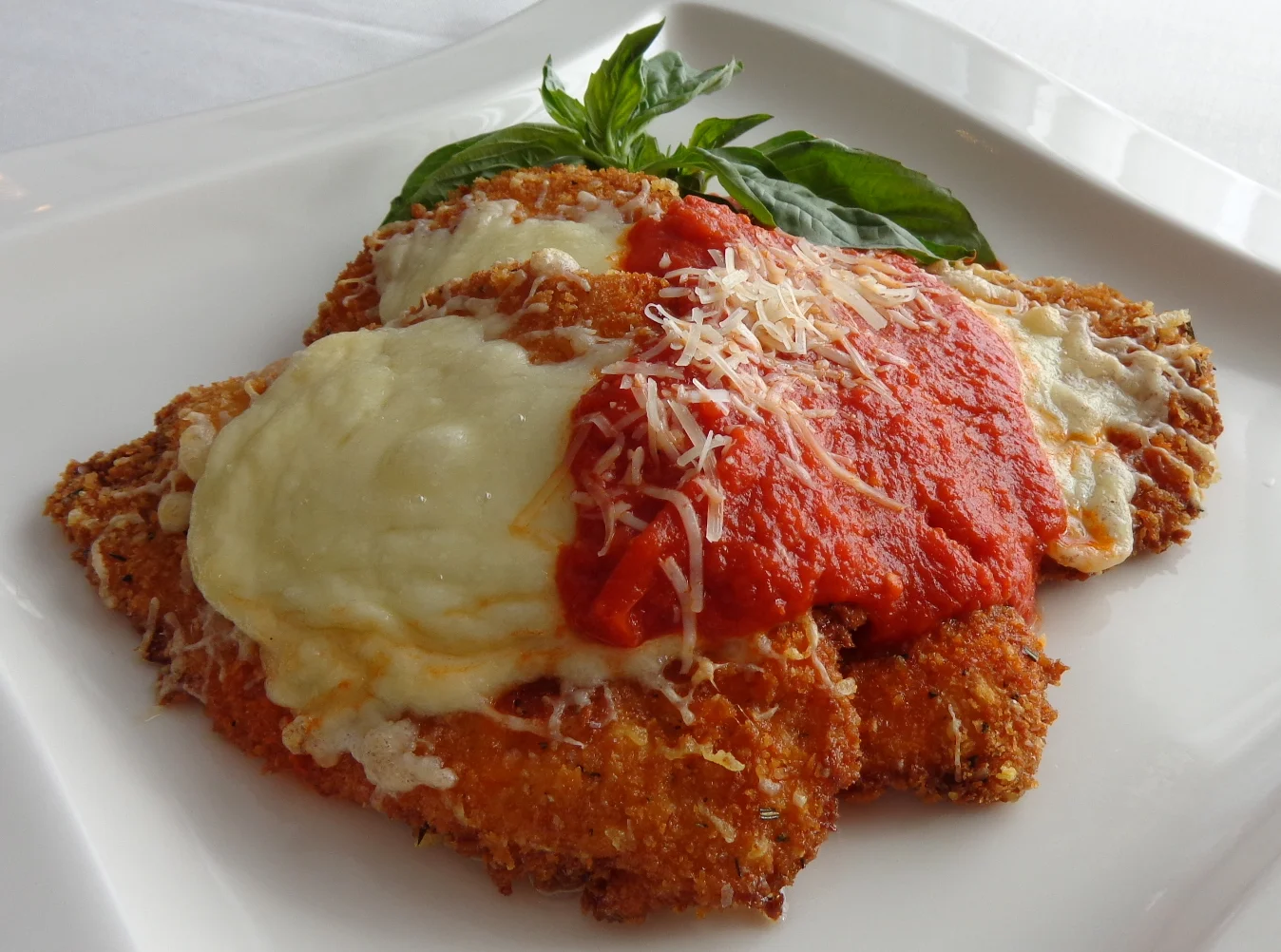 CHICKEN PARMESAN Hand Battered & Pan Fried. Topped with Marinara & Provolone Cheese.