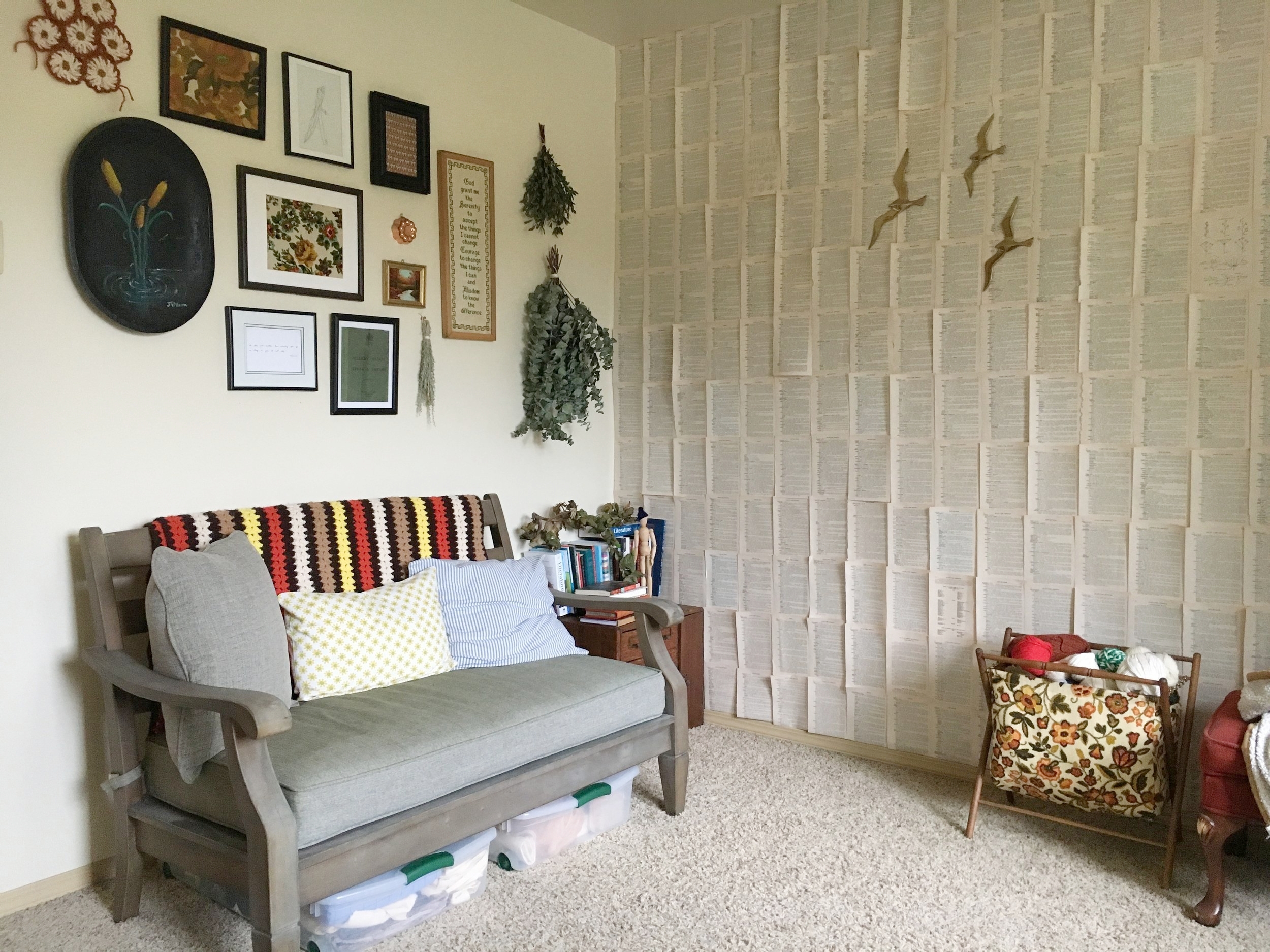 For a long time this room was just a mash-up of all our cast-off decor and furniture, so I felt completely uninspired here. I saw inspiration for a wall of book pages and felt it would add texture but not too much color or distraction. The birds and yarn caddy are thrifted, and the mostly second-hand yarn I use for weavings and macrame and sometimes personal crochet projects.