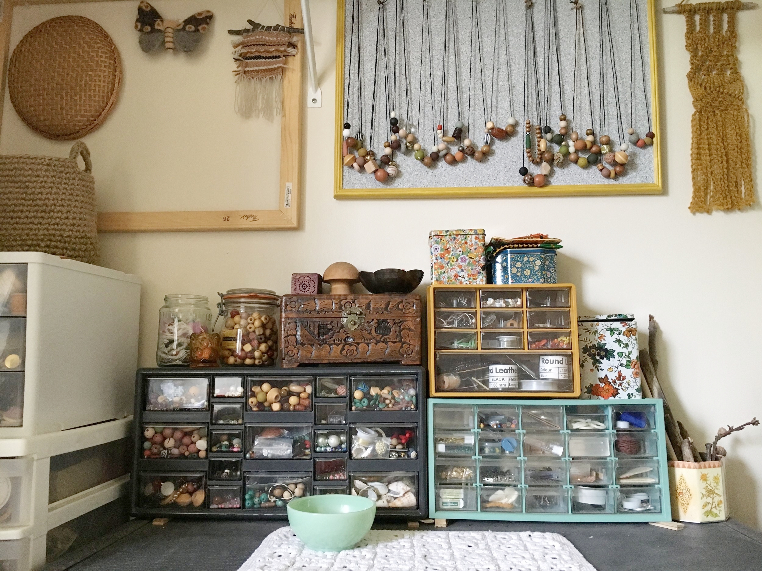 This is a closer view of where I store my beads and completed necklaces. I've taken thecork board as a display at craft fairs, and it helps to keep the necklaces here in the studio, too. I also hang my work-in-progress weavings and macrame, and felted items here.
