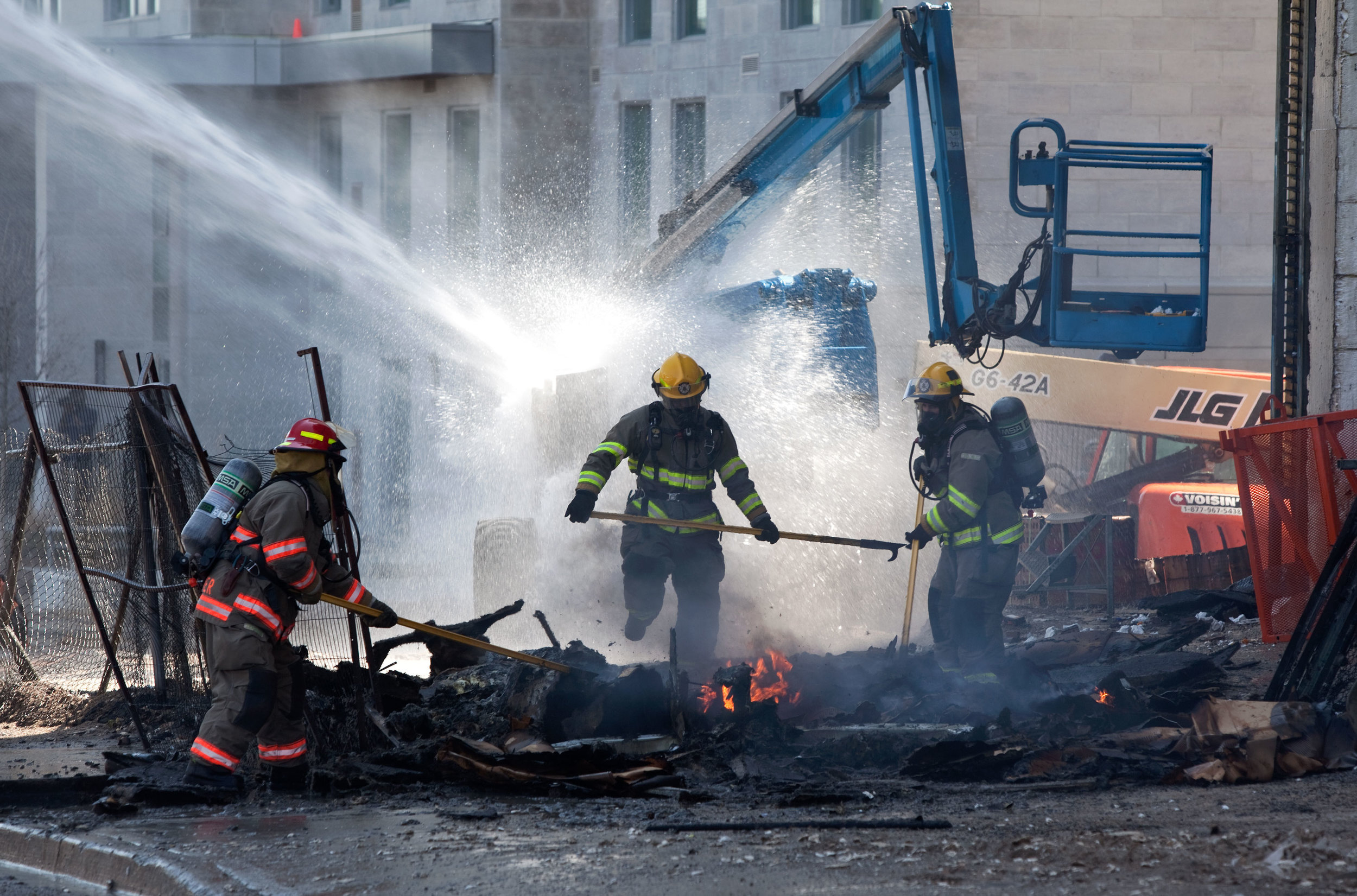Firefighters finish off a blaze started when a lift overheated and exploded at a construction site in Waterloo.