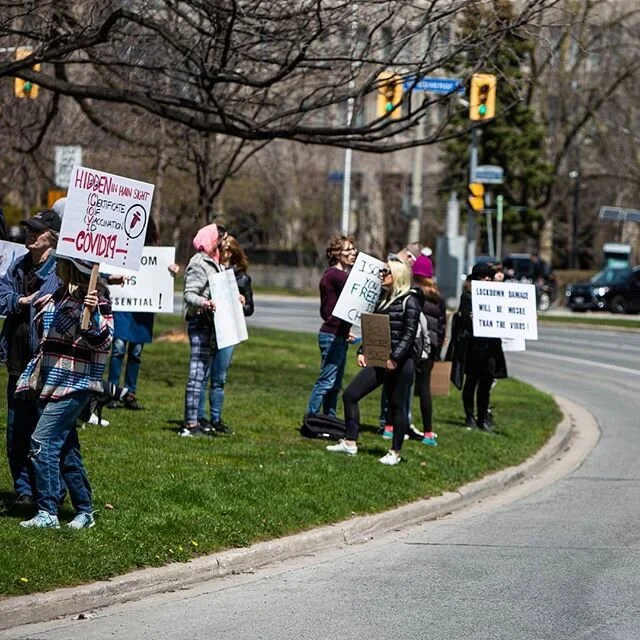 A group of anti-lockdown protesters turn away as a motorcyclist gives them the middle finger, April 25, 2020. Shot for @nowtoronto #covid_19 #coronavirus #toronto #torontophoto #torontolife #torontophotographer #onassignment #photojournalism #canonca