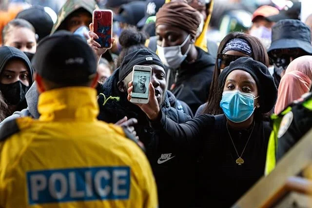A protestor holds up a photo of Regis Korchniski-Paquet to a Toronto police officer during the #notanotherblacklife march, Saturday May 30, 2020. Shot for @nowtoronto I have deleted my black square from yesterday, it was posted in solidarity but ulti