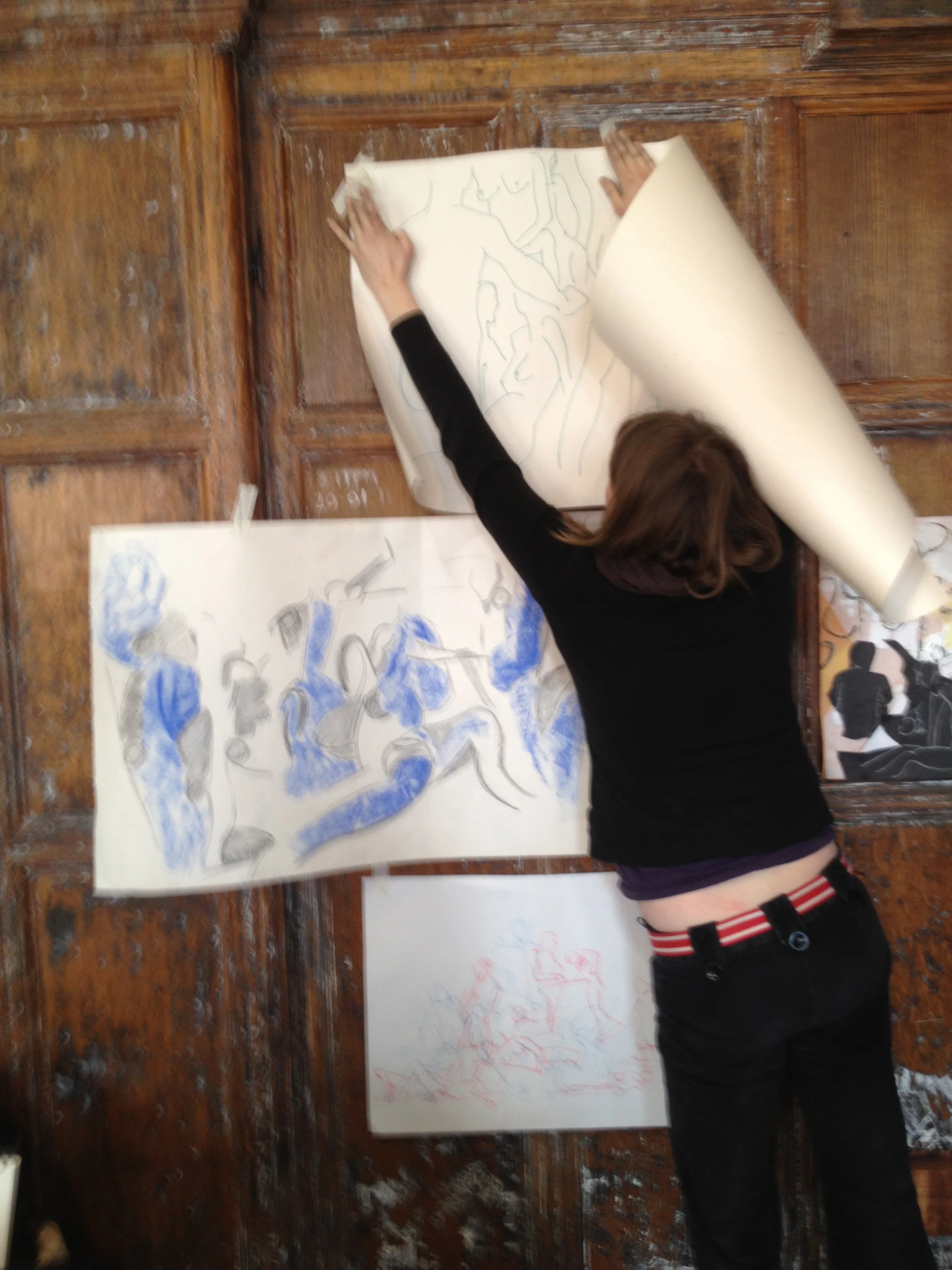An artist attending a London Drawing event at the Battersea Arts Centre tapes one of her drawings to the wall.