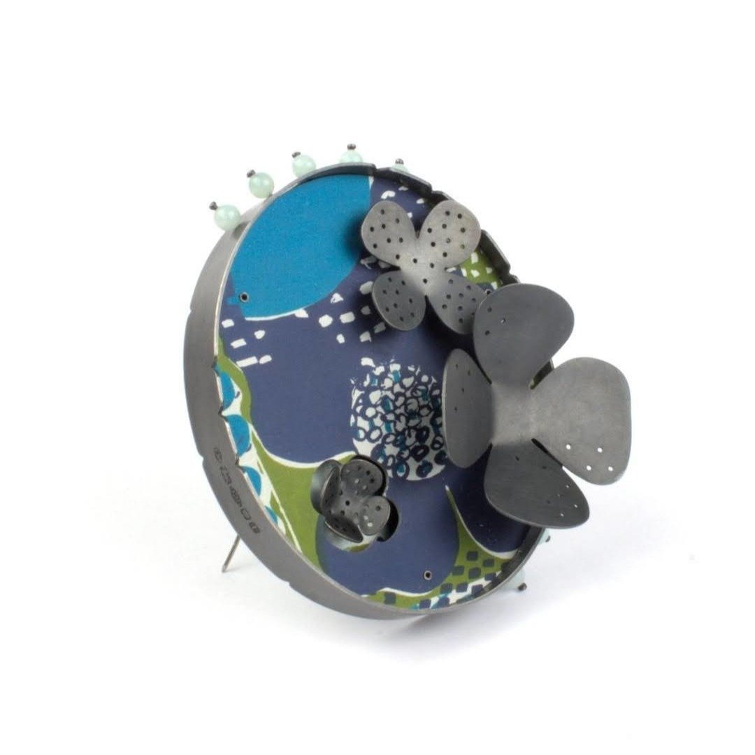 'Flower Bed' brooch by Lindsey Mann @lindseymannjewellery 

Colour and print are at the heart of every piece Lindsey makes. Working predominantly with anodised aluminium sheet, she treats the metal as a canvas for vibrant screen prints. Combining the