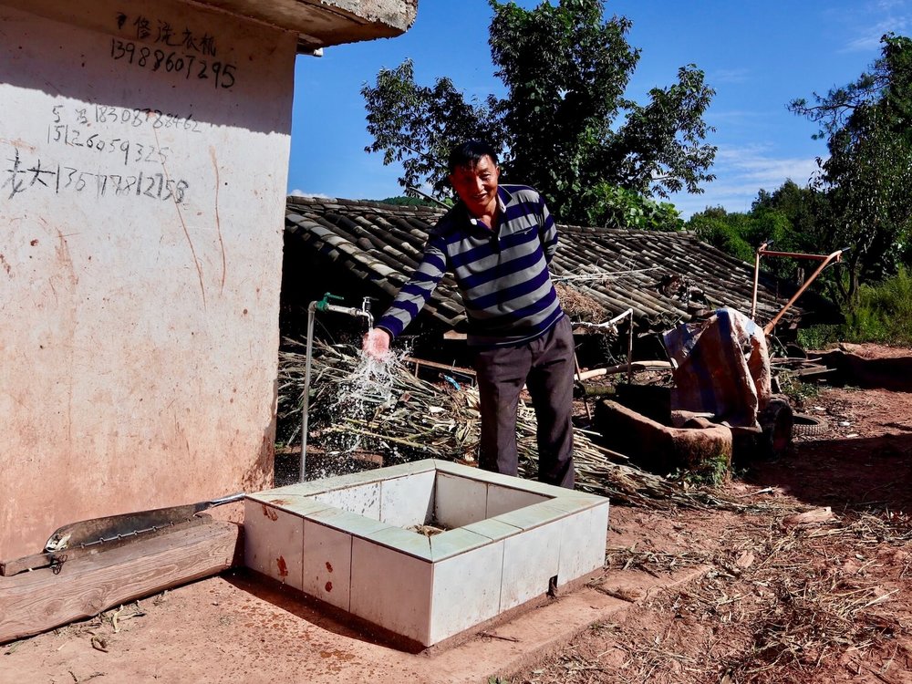 A happy customer at a new drinking water project site in rural Yunnan