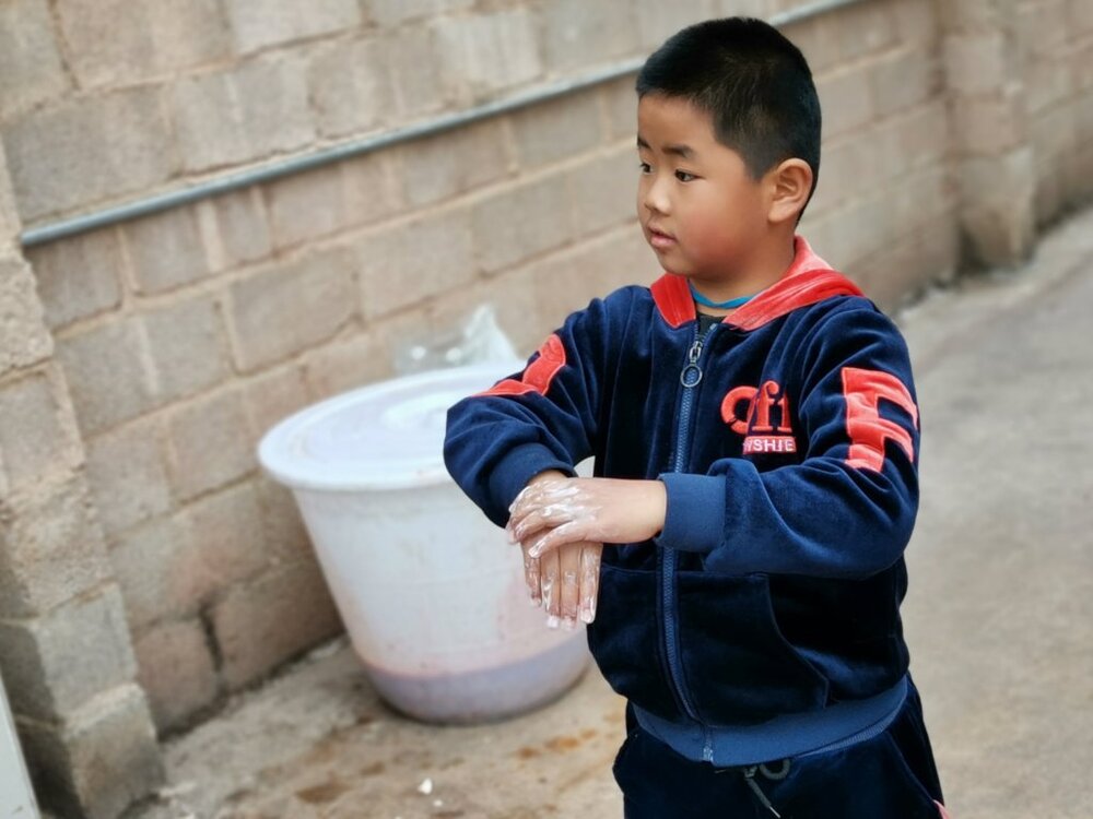 A member of our HEAL health training, learning how to properly wash hands