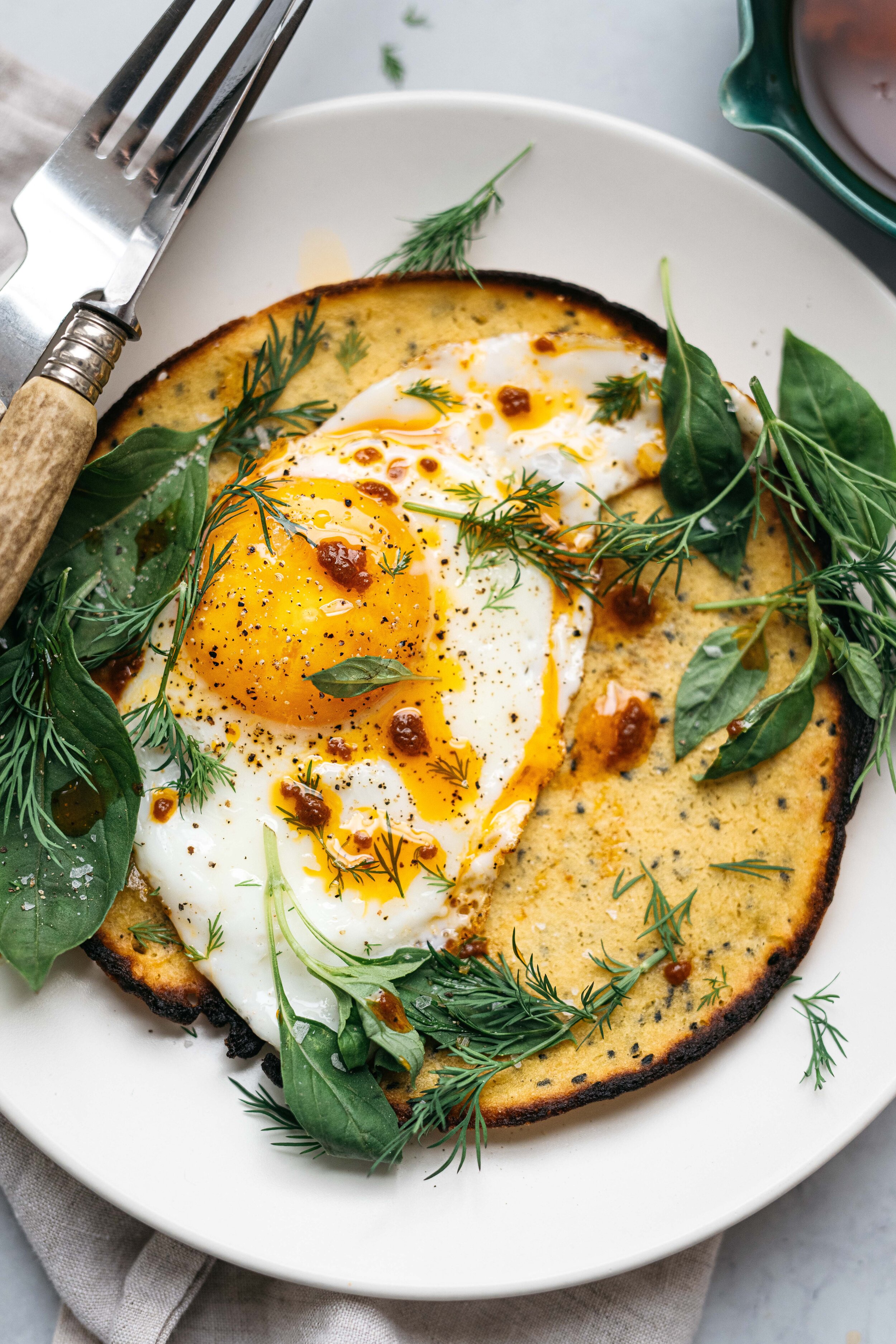 BREAKFAST FOR DINNER: GARLICKY SOCCA W/ FRIED EGGS, HERBS & HARISSA OIL | dolly and oatmeal