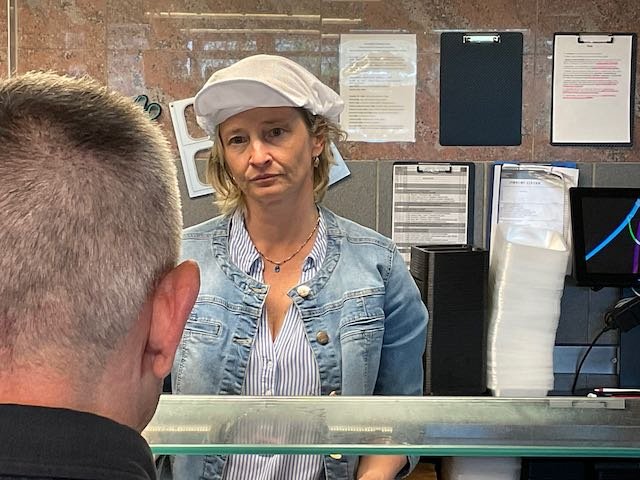 CUT…to see the lunch lady, staring at Maxime like a statue with no patience.
