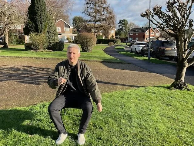  And here’s ANDREAS, again. Now seated at a table, sipping tea while holding the leads of two English Bulldogs. 