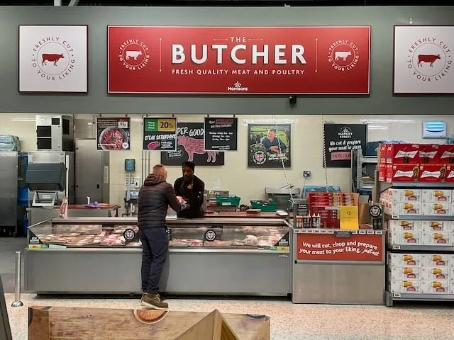  …to the BUTCHER handing the WRAPPED STEAKS to the MOM, who turns and… 