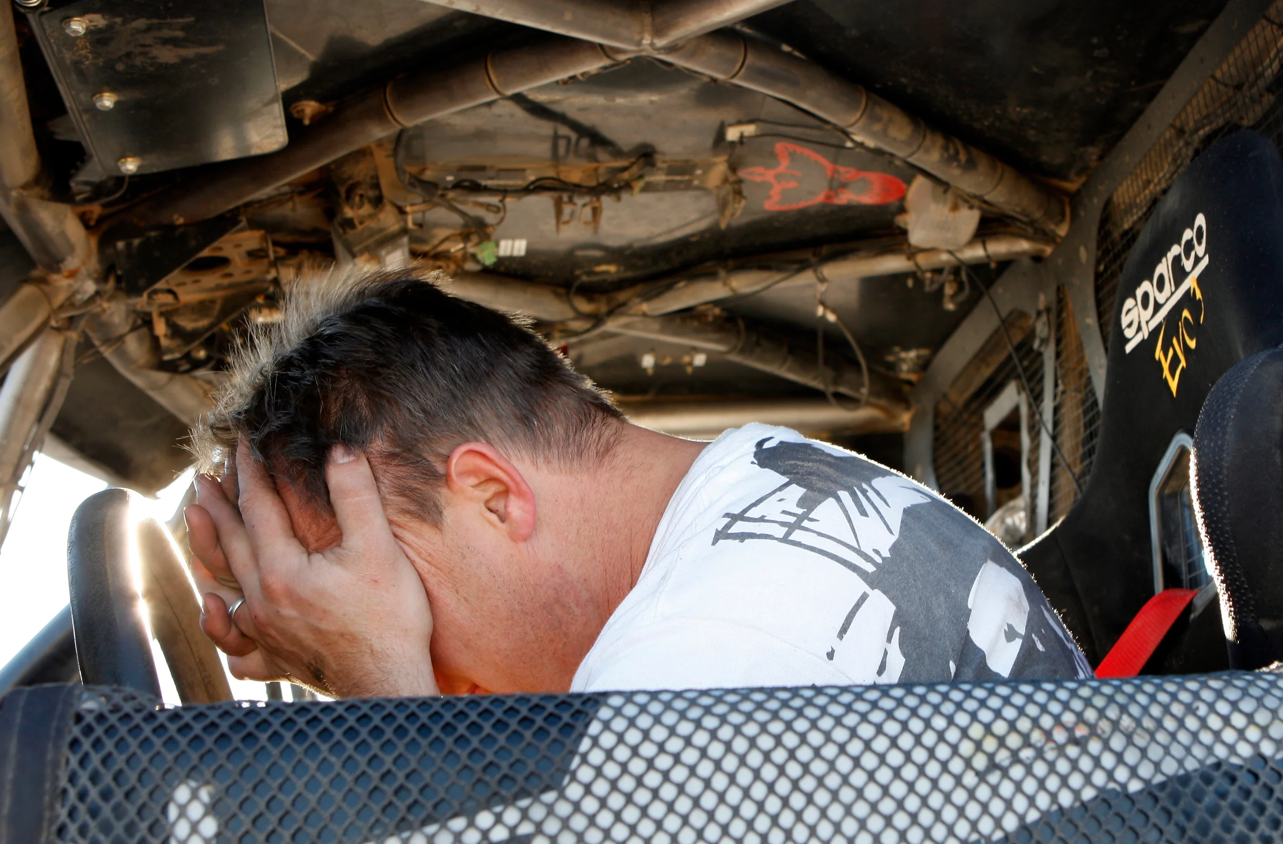  A disappointed team crew chief retrieves the broken race truck on the course after the race.&nbsp; 