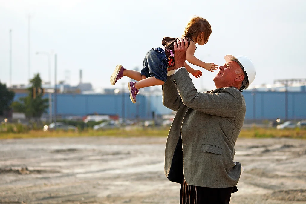  A grandfather holds up his granddaughter outside a plant in Peoria, Illinois.&nbsp; 