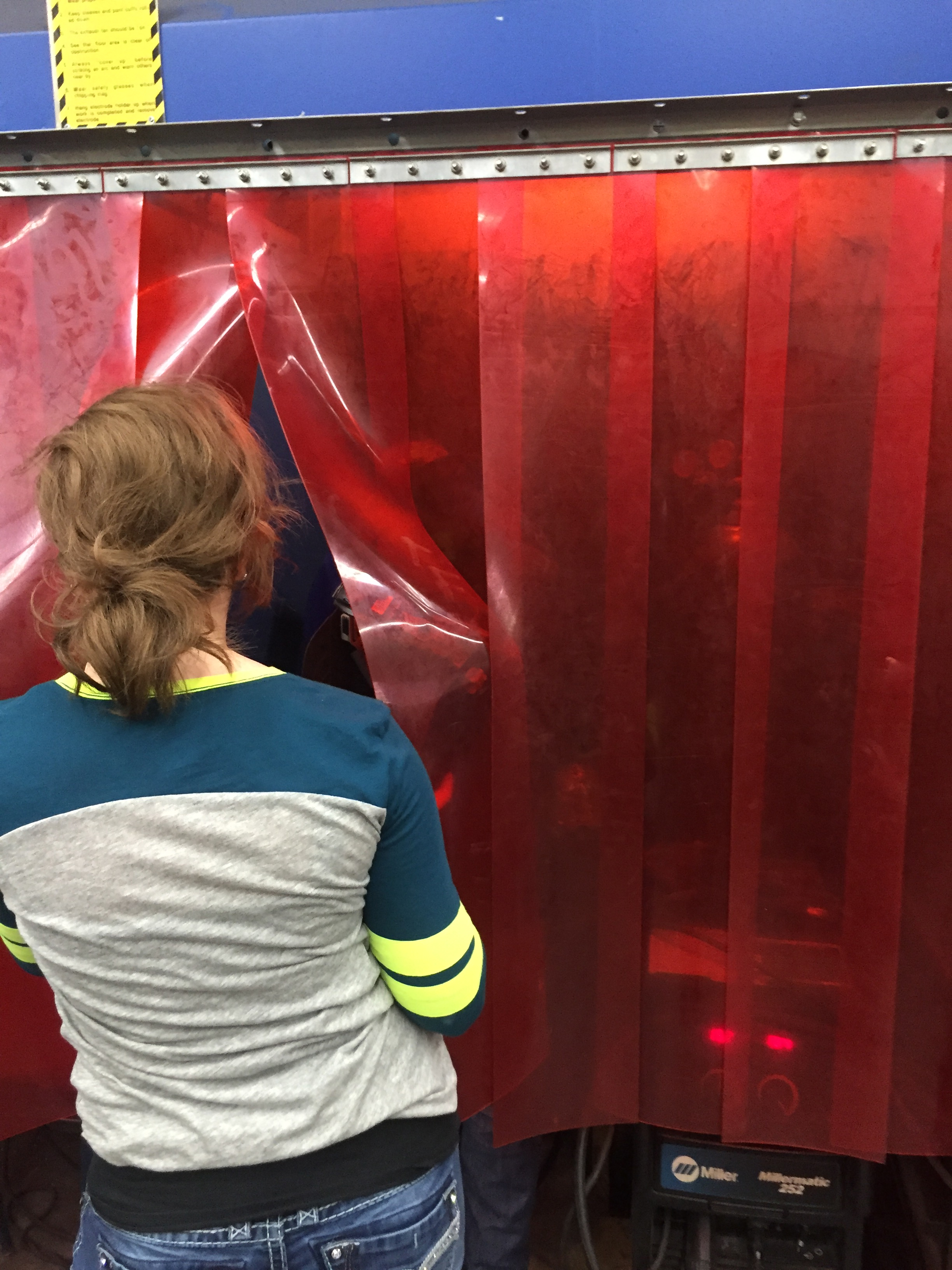 High school student watching the boys weld during an artist in residence with teaching artist, Heidi Jeub, 2016